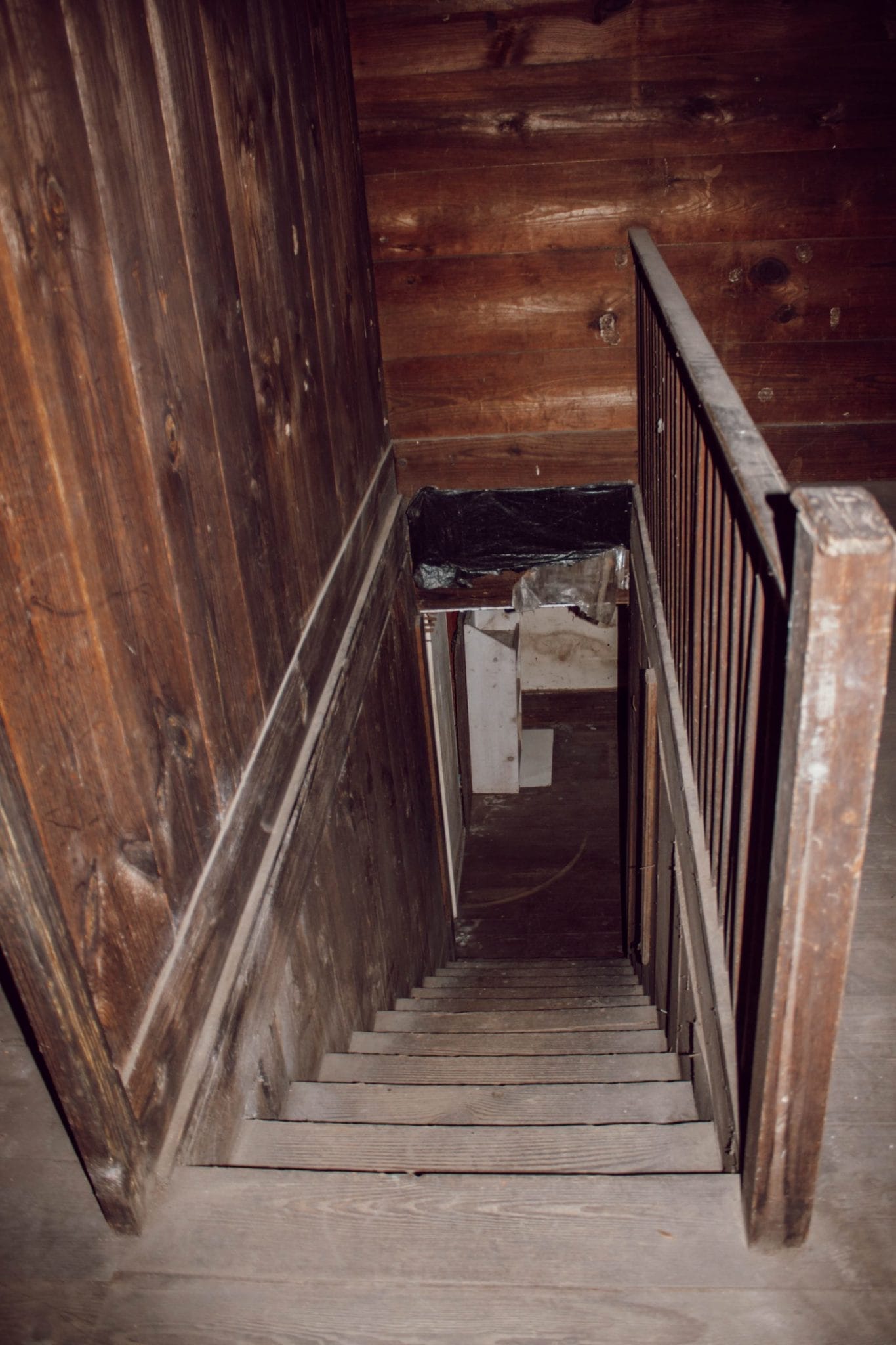 stair railing in 1800's NC farmhouse upstairs bedroom with original shiplap on walls and wood floors