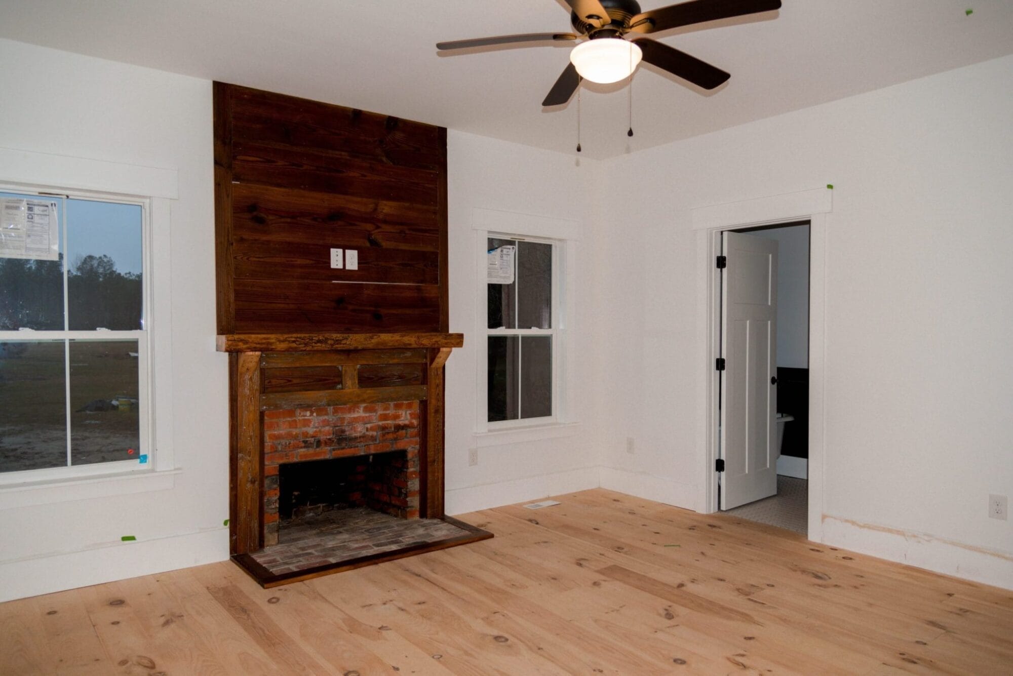 renovated room with reclaimed wood fireplace and wide pine floors