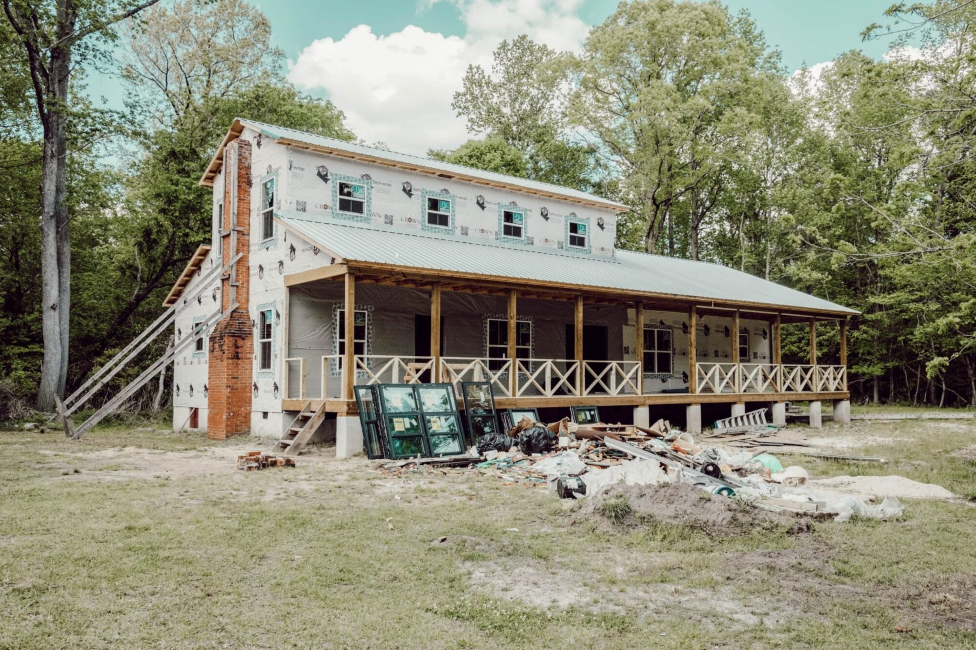 white farmhouse with metal roof mid construction