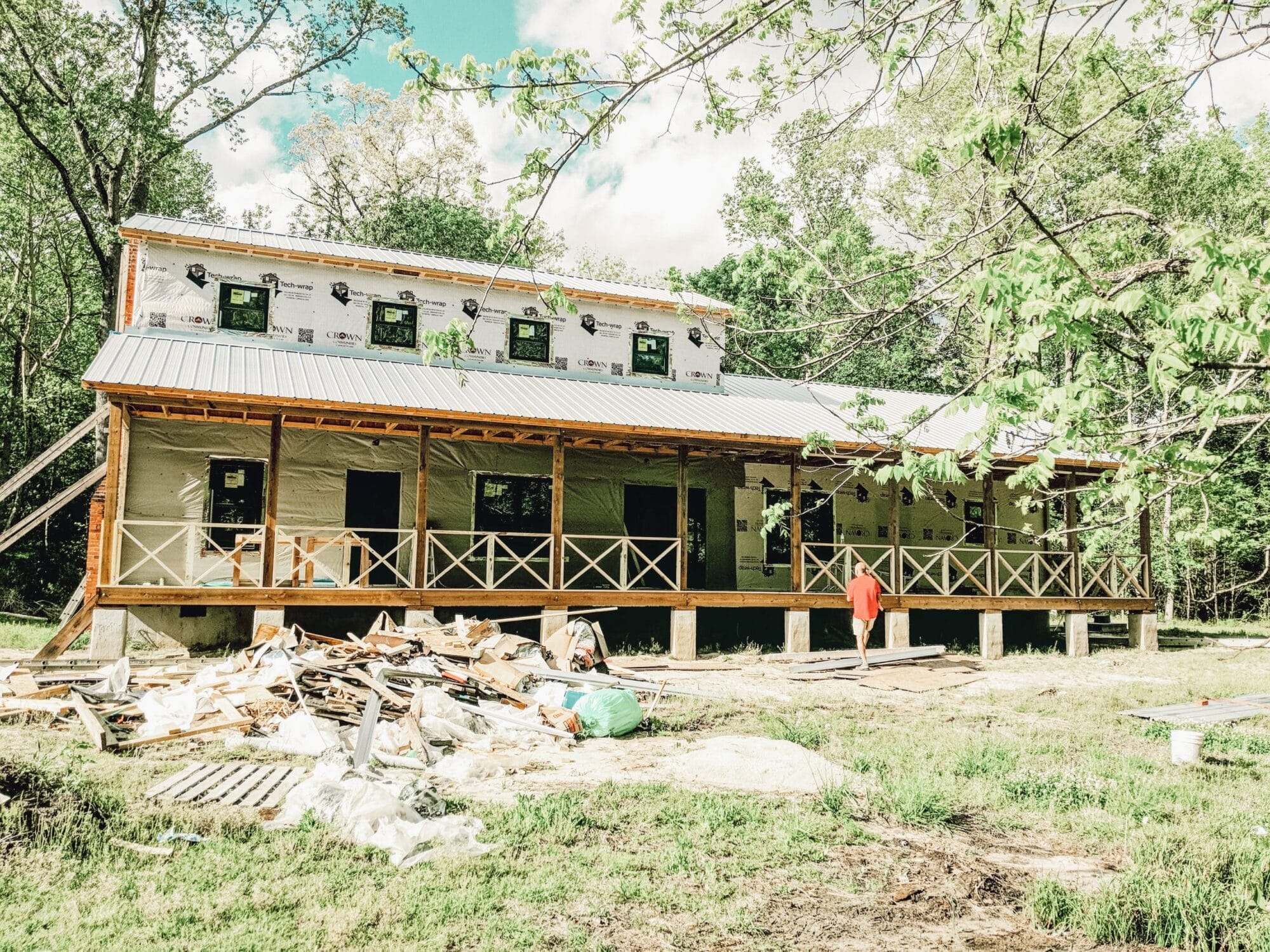 farmhouse with large front porch during construction