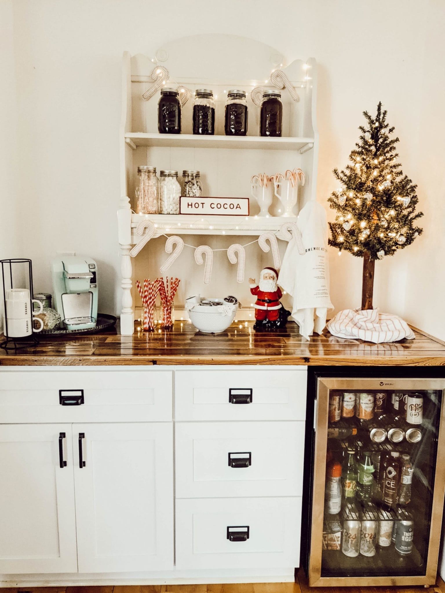 farmhouse coffee bar with white shaker cabinets, built in beverage cooler, and wood countertops