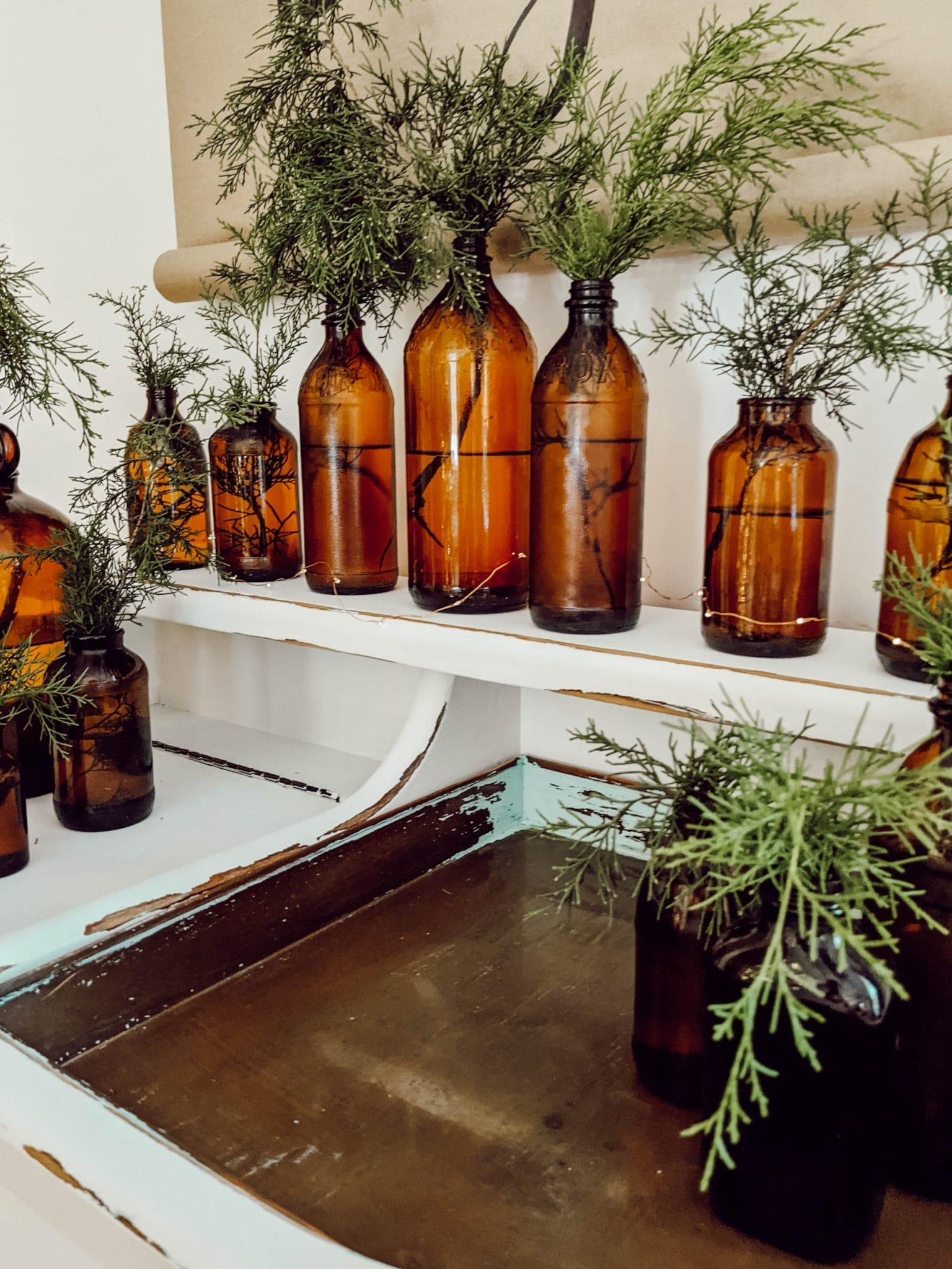 collection of vintage amber glass bottles with real cedar greens