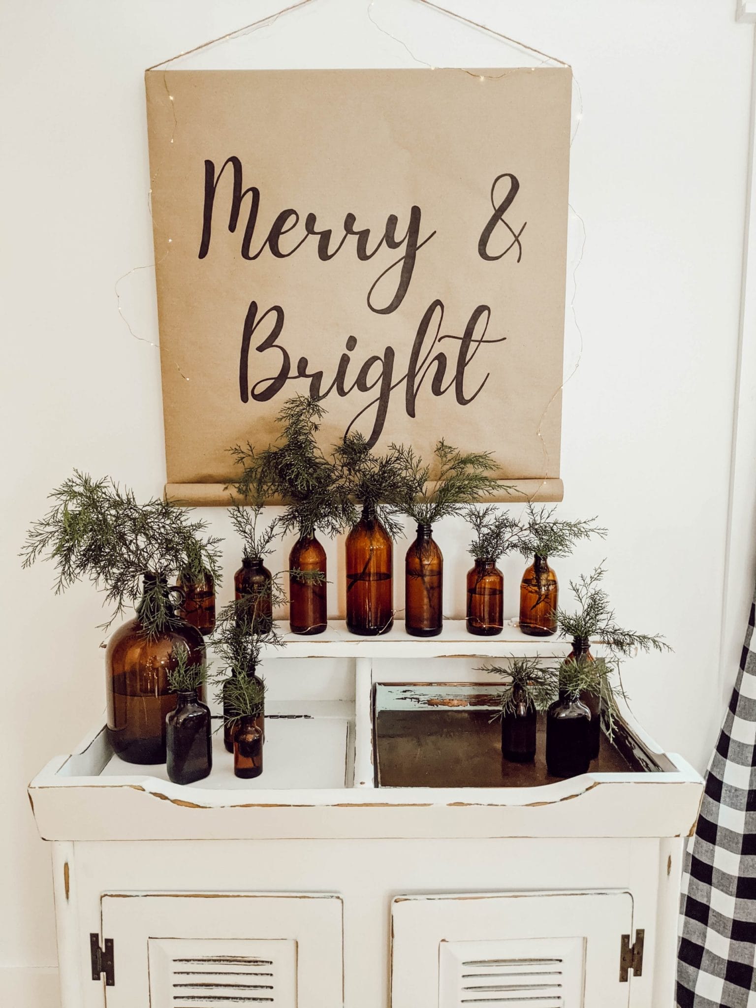 amber glass, cedar trimmings, and farmhouse scroll sign around vintage dry sink