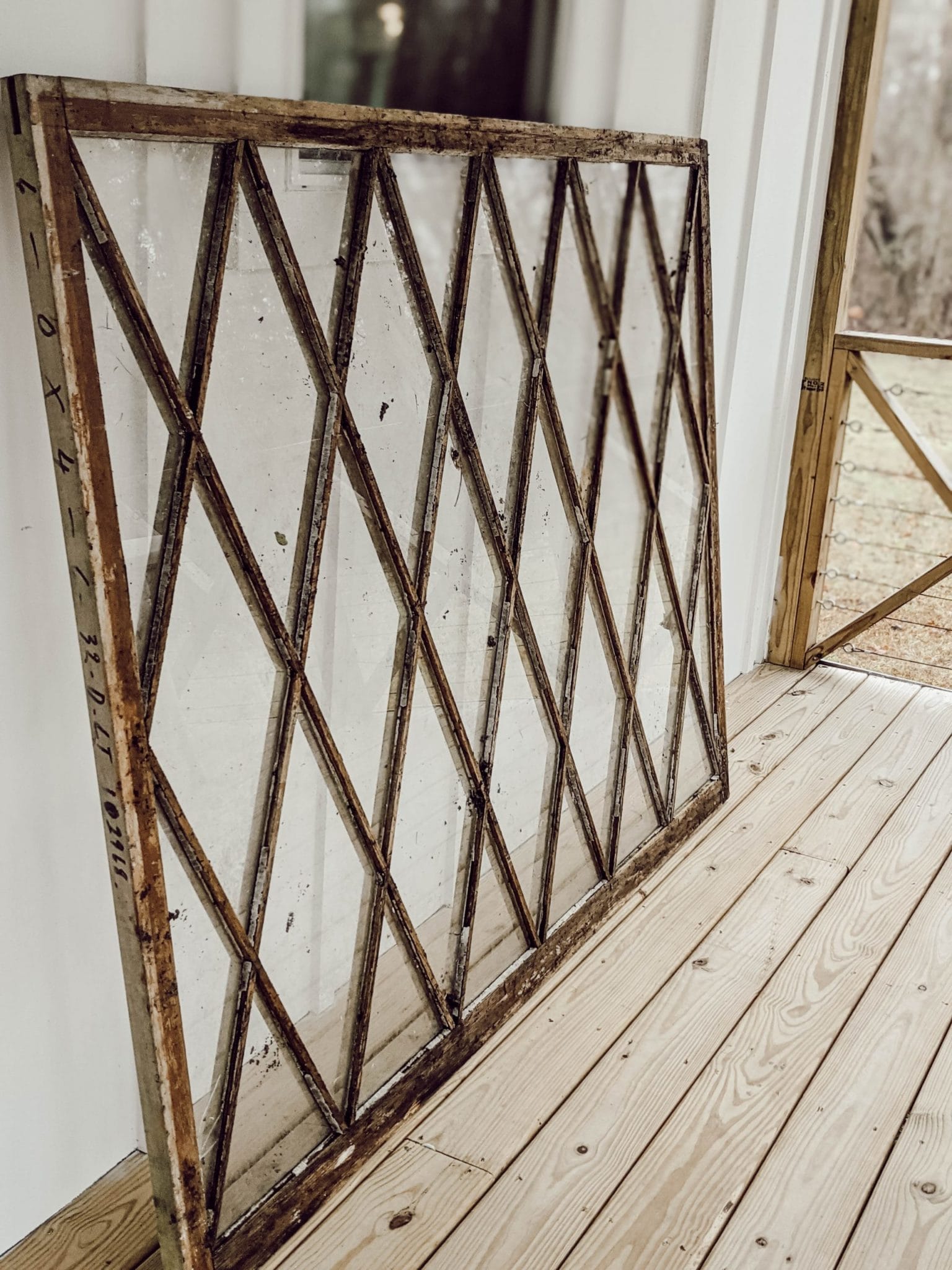 large weathered wood window with diamond panes