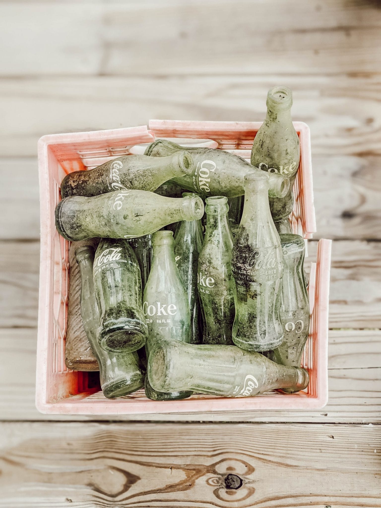 red plastic crate of vintage green glass coca cola bottles