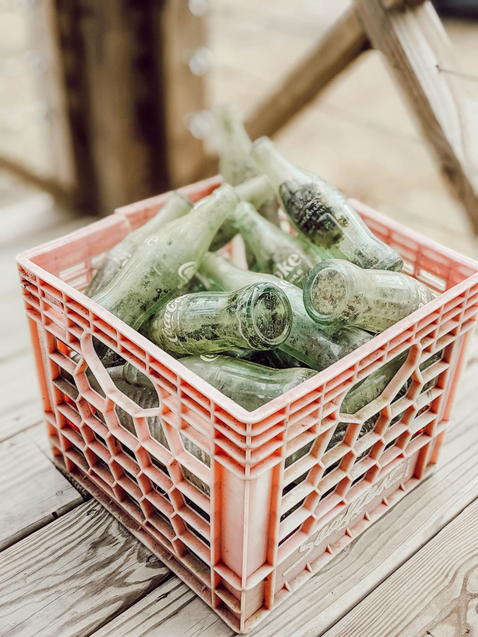red plastic crate of vintage green glass coca cola bottles