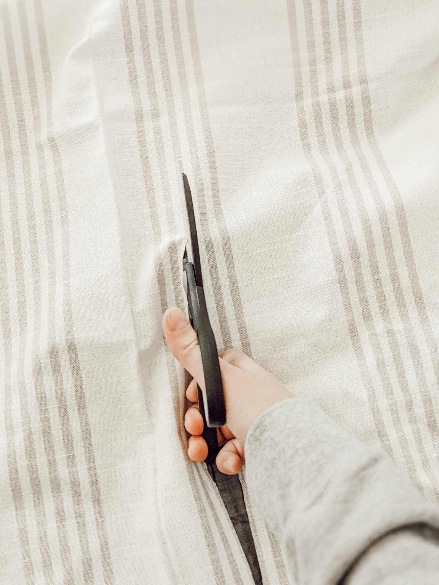 cutting gray and white striped fabric