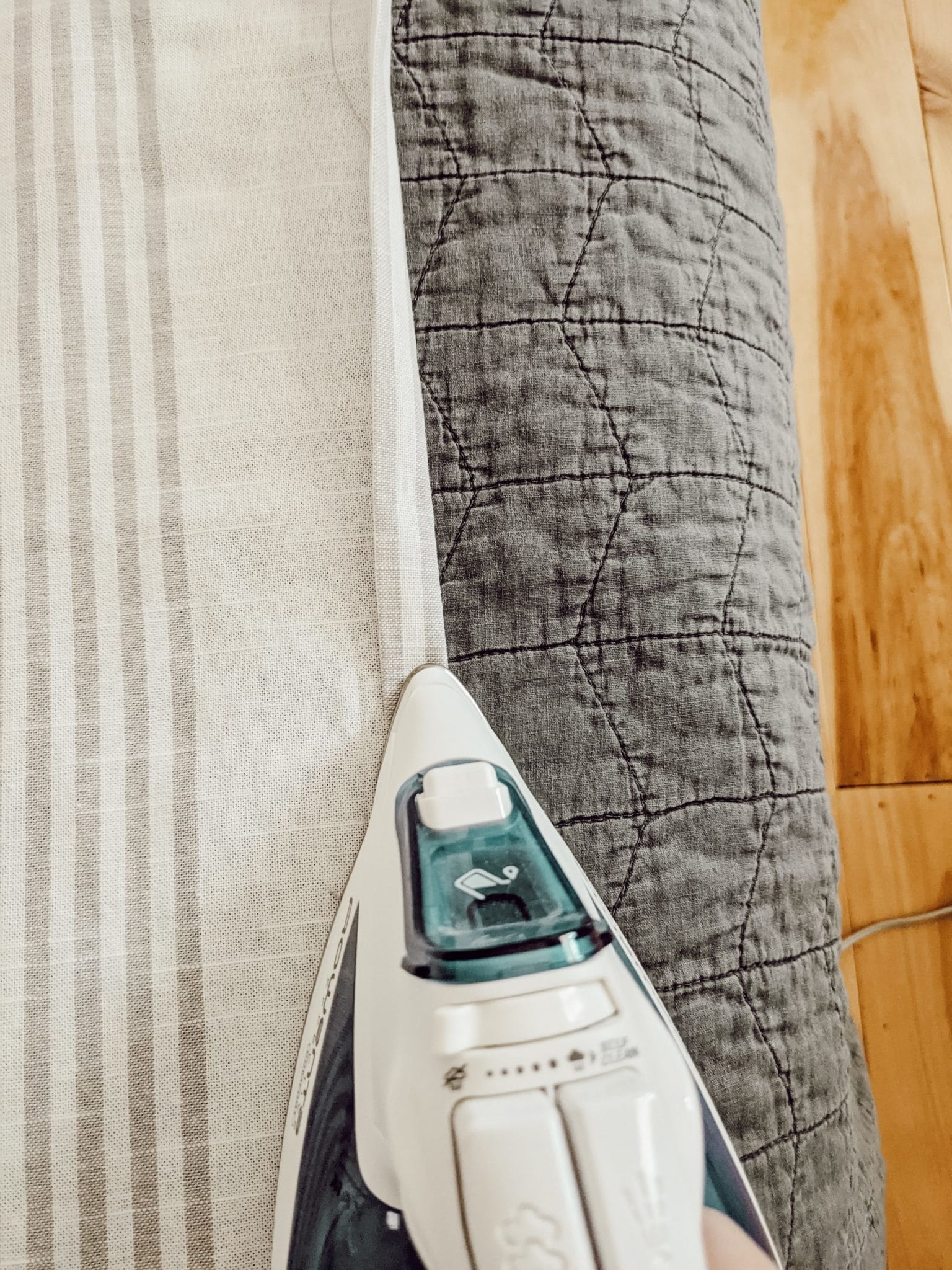 ironing the hem of a curtain before sewing