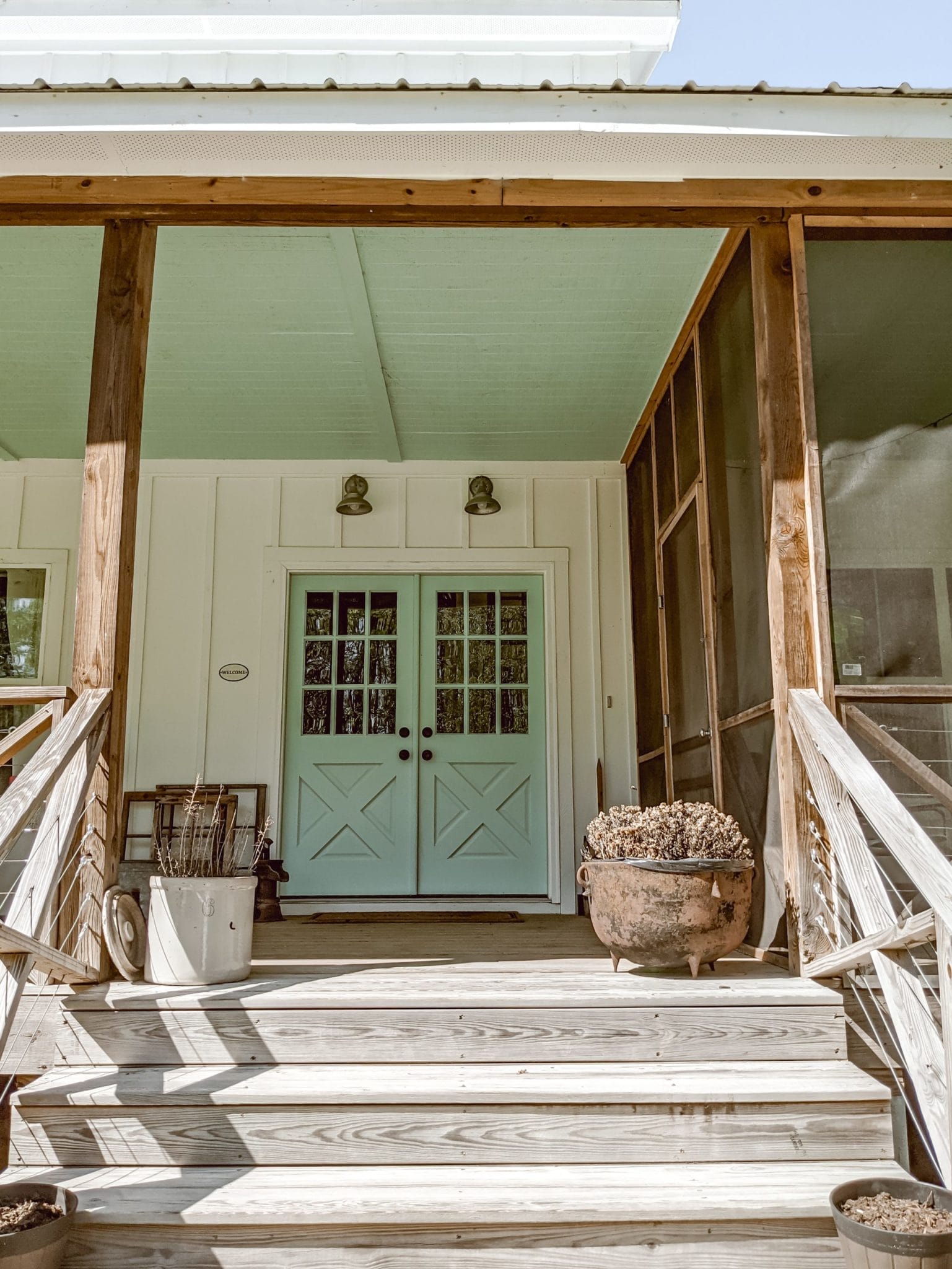 farmhouse double entry doors, board and batten siding, and a blue porch ceiling