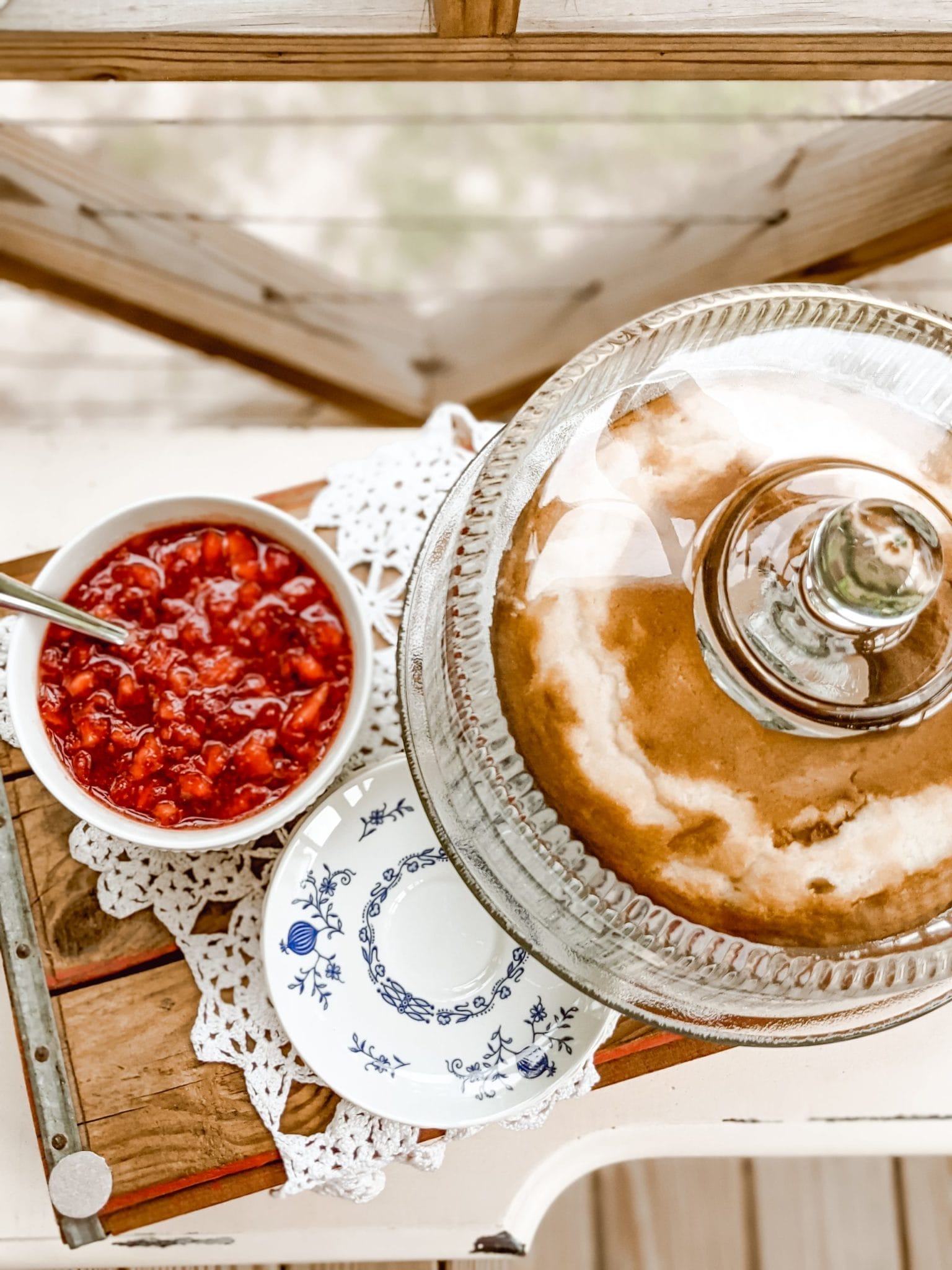 pound cake on a glass cake stand and mashed strawberries