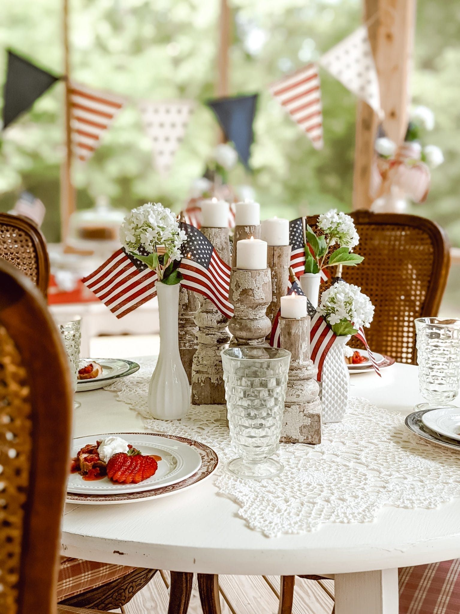 Memorial Day and 4th of July vintage centerpiece with candles, milk glass, and mini flags