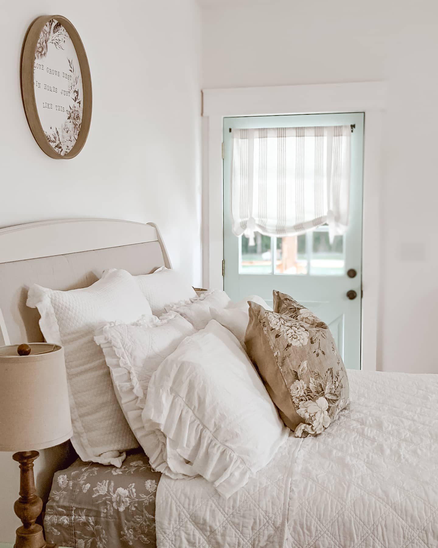 cozy white cottage bedding with floral sheets and a floral throw pillow