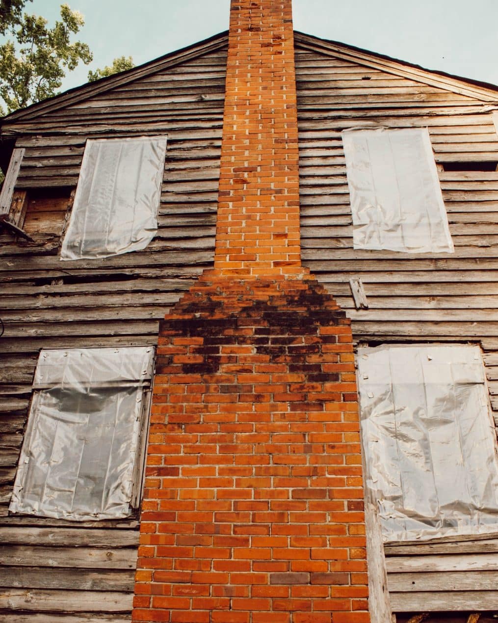 1800's NC farmhouse exterior with wood siding and brick chimney