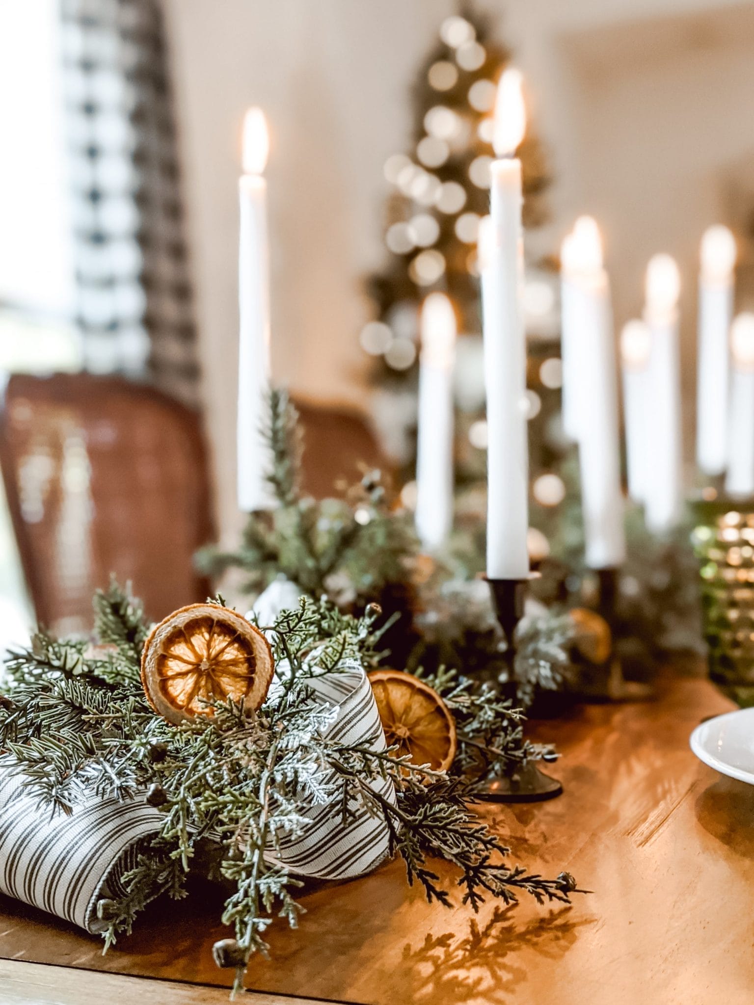 classic Christmas centerpiece with orange slices, ticking ribbon and brass candlesticks