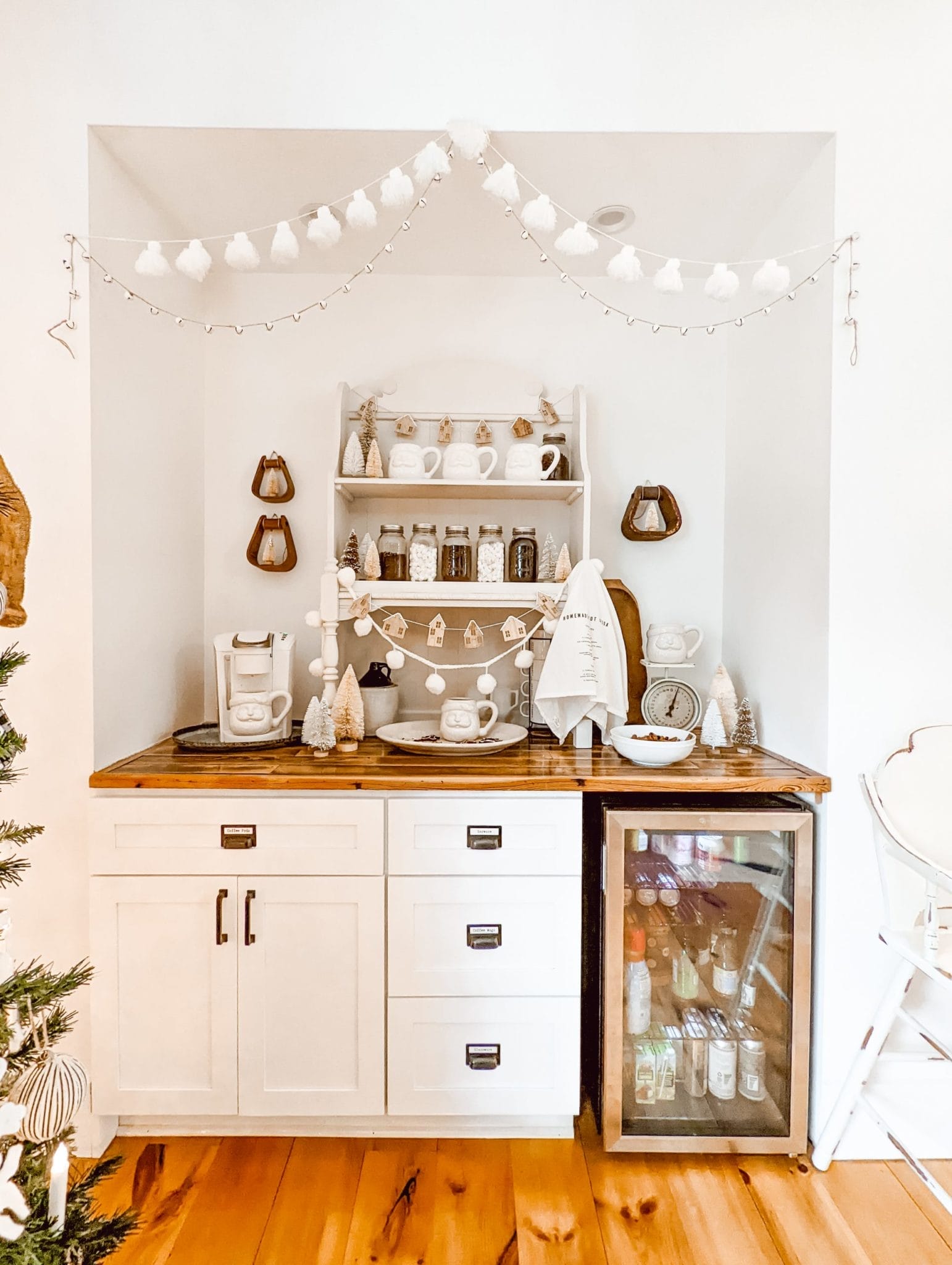 neutral Christmas cocoa bar with white Santa mugs and vintage wood decor