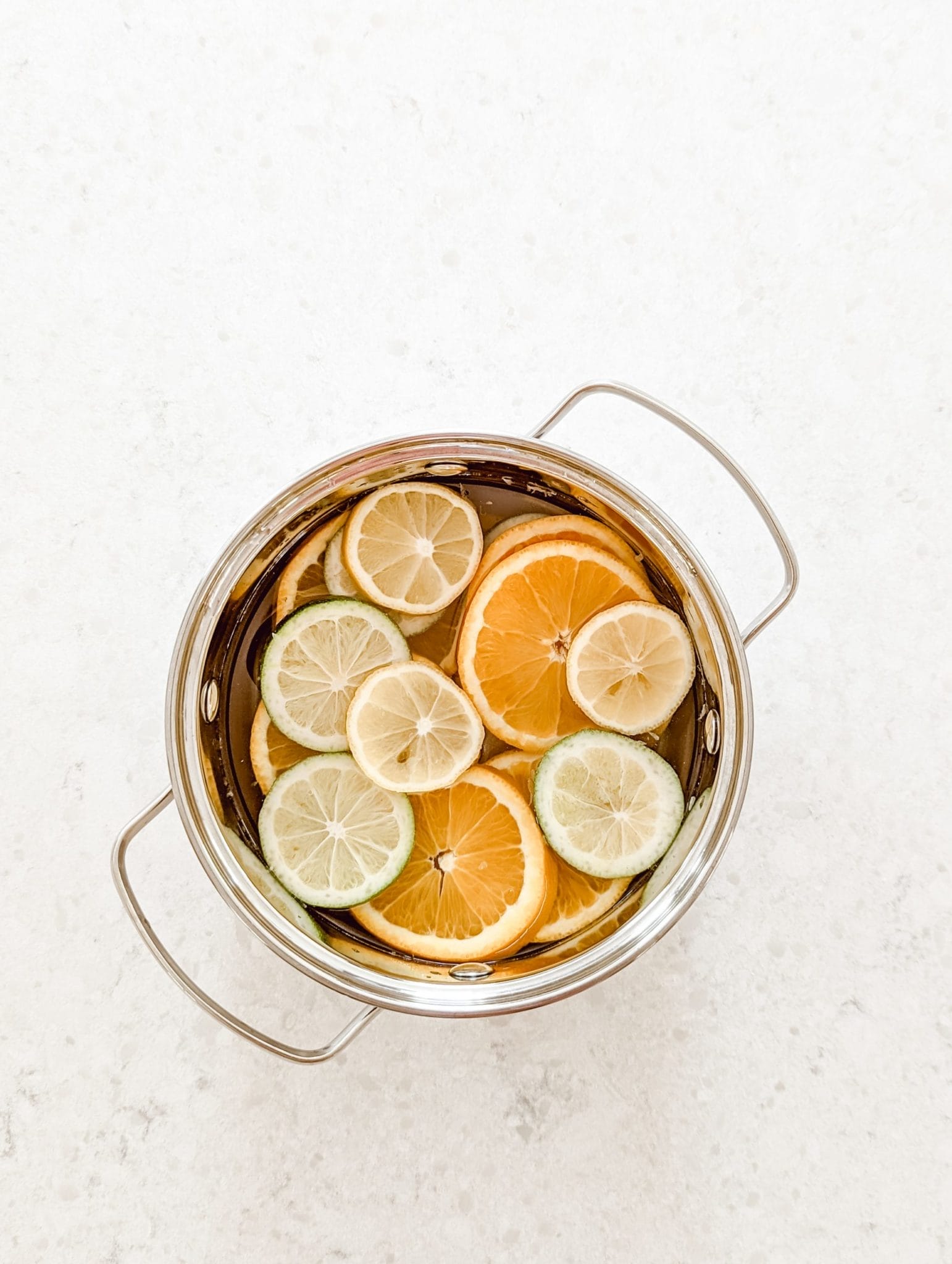 fresh smelling spring simmer pot recipe with sliced limes, lemons, and oranges, and coconut extract