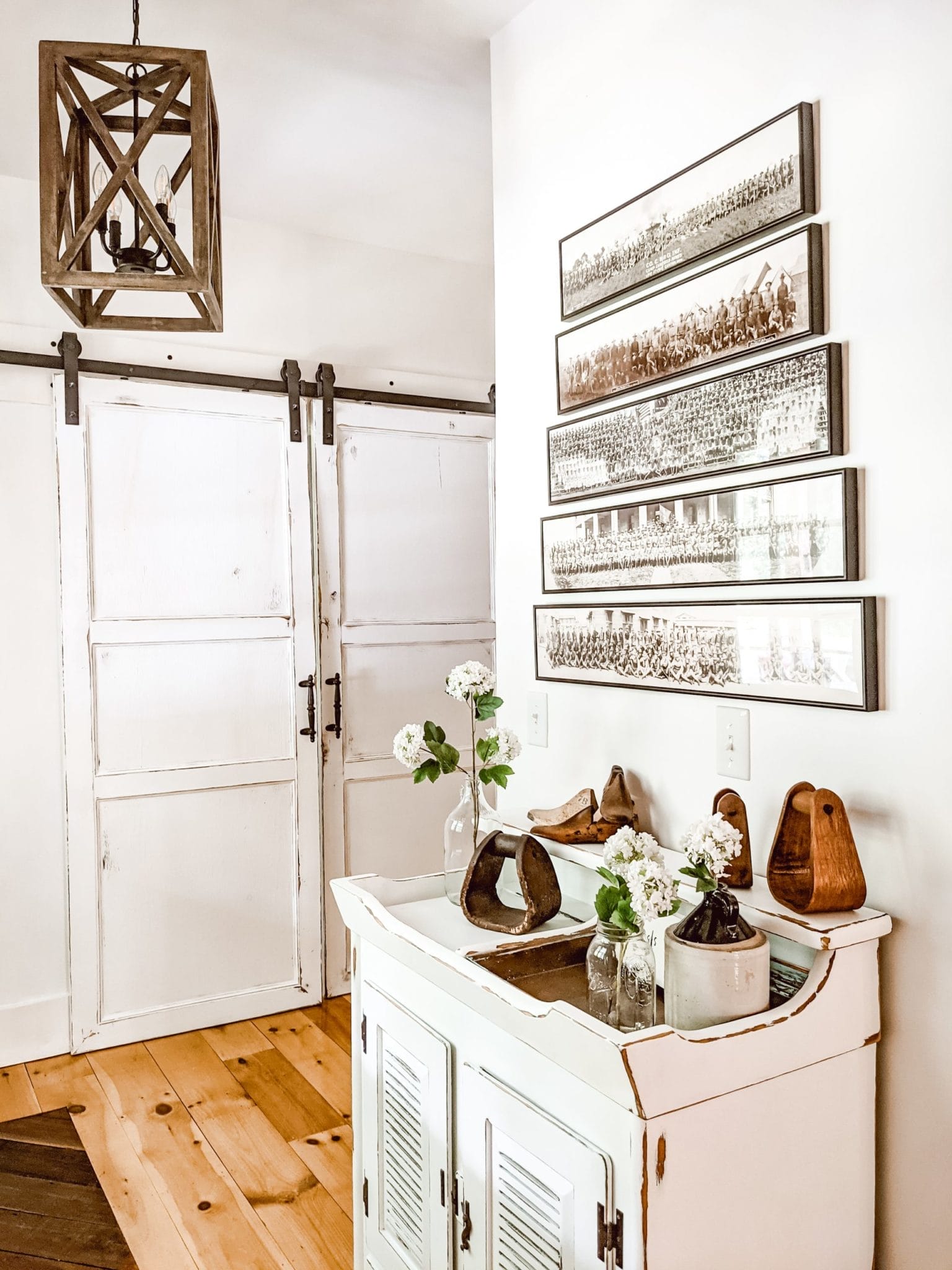 white farmhouse entryway with vintage military panoramic photos and chippy painted dry sink