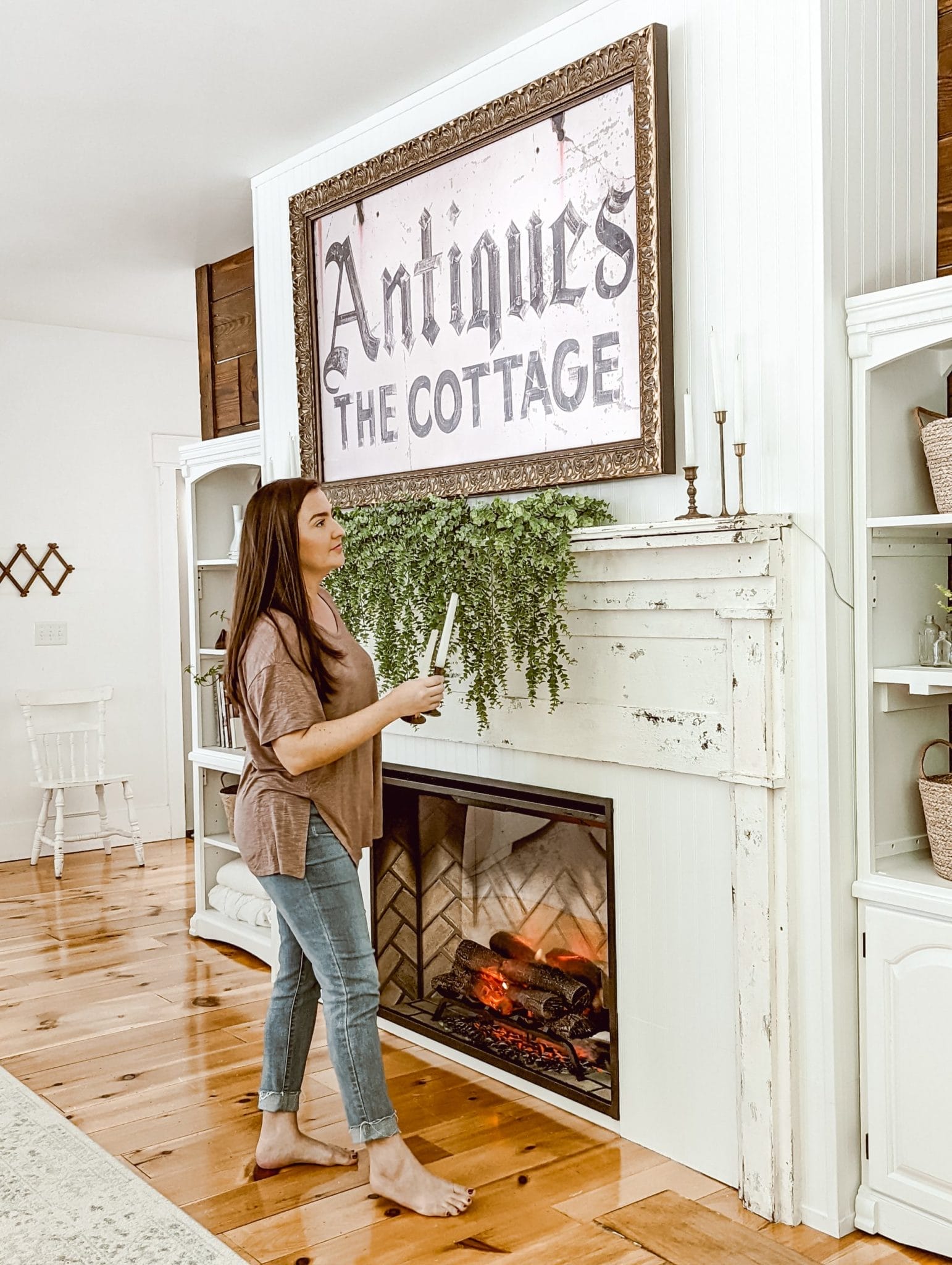 Brittany of White & Woodgrain adding brass candlesticks to our new farmhouse cottage DIY fireplace