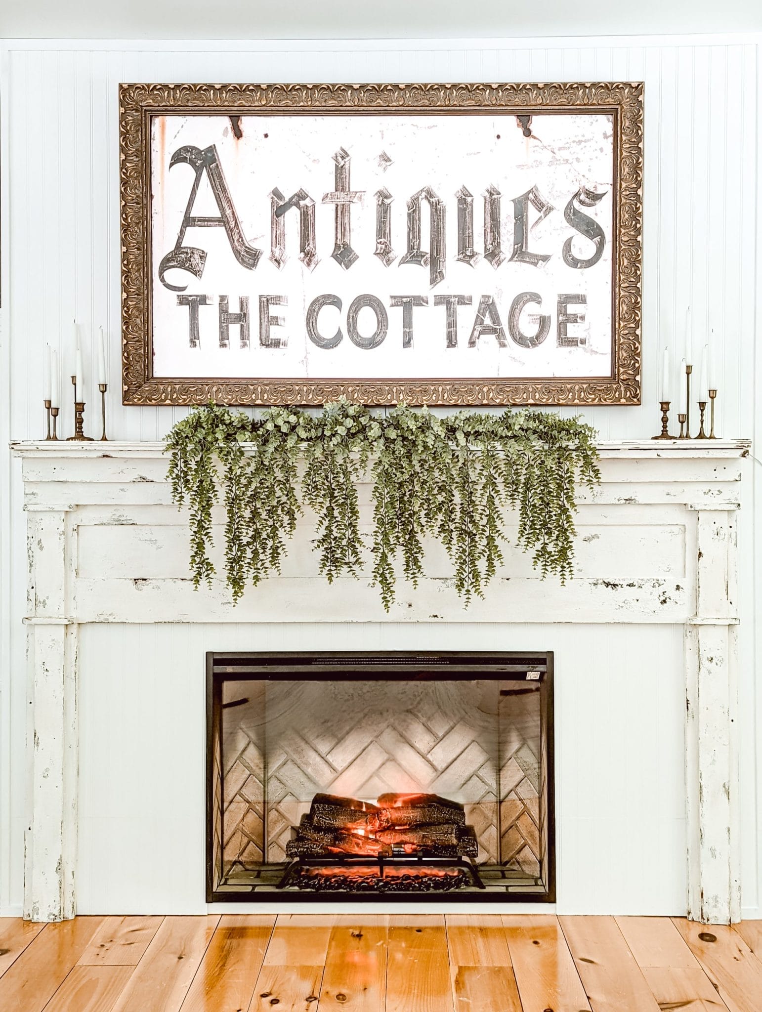 DIY fireplace with electric insert, chippy white antique mantel, and a frame TV above the mantel