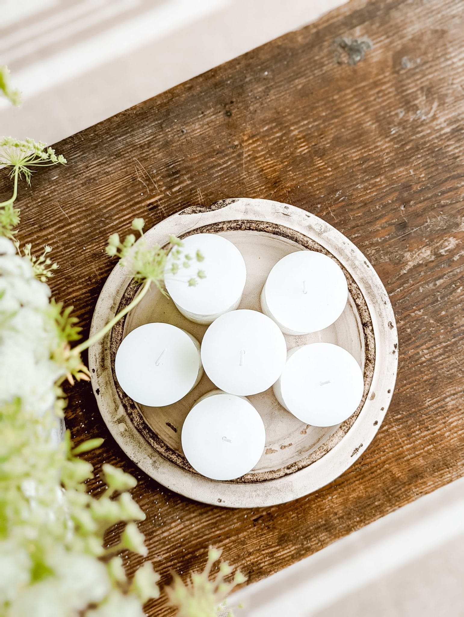 citronella pillar candles arranged on an antique crock lid