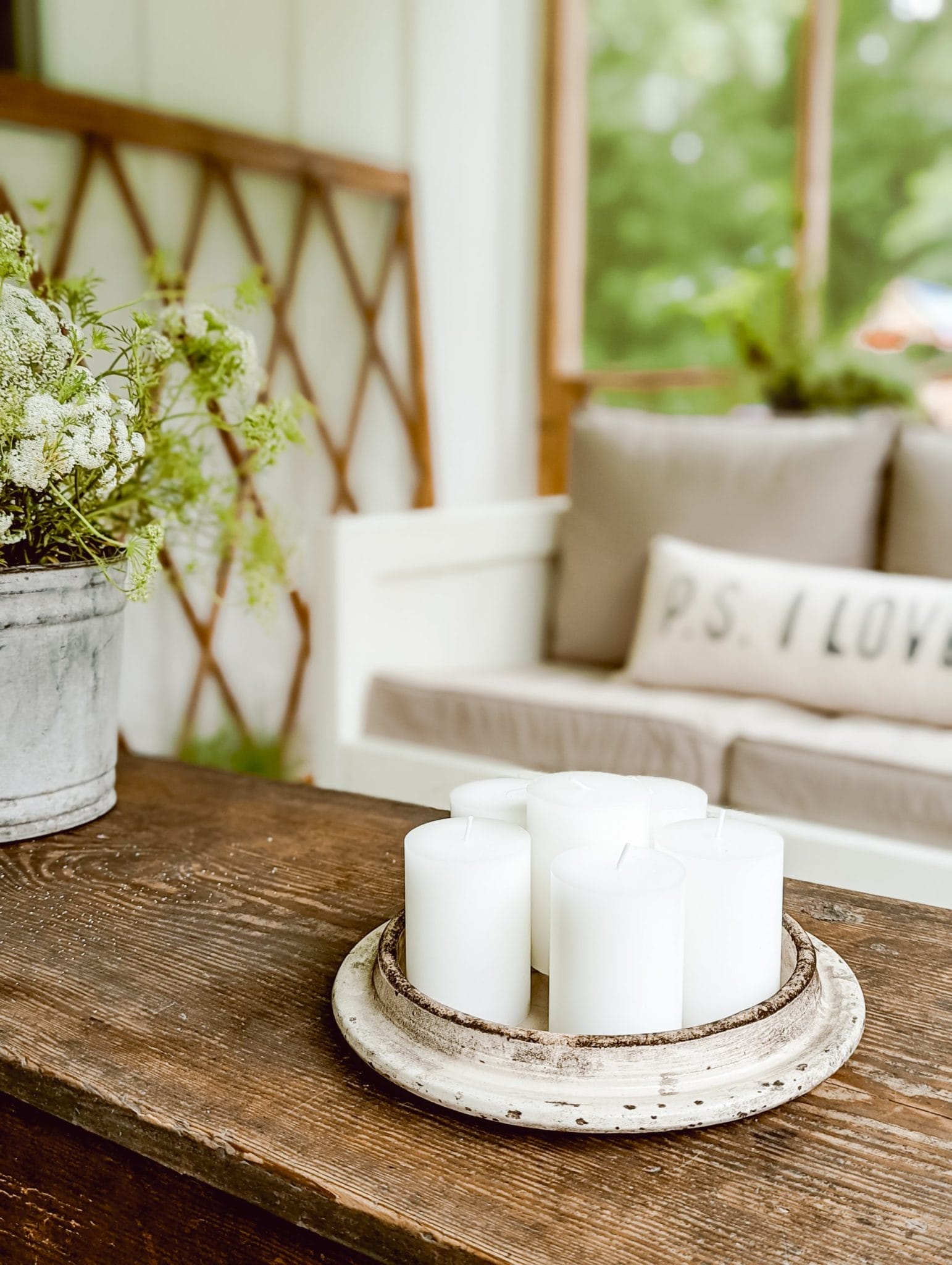 citronella pillar candles arranged on an antique crock lid