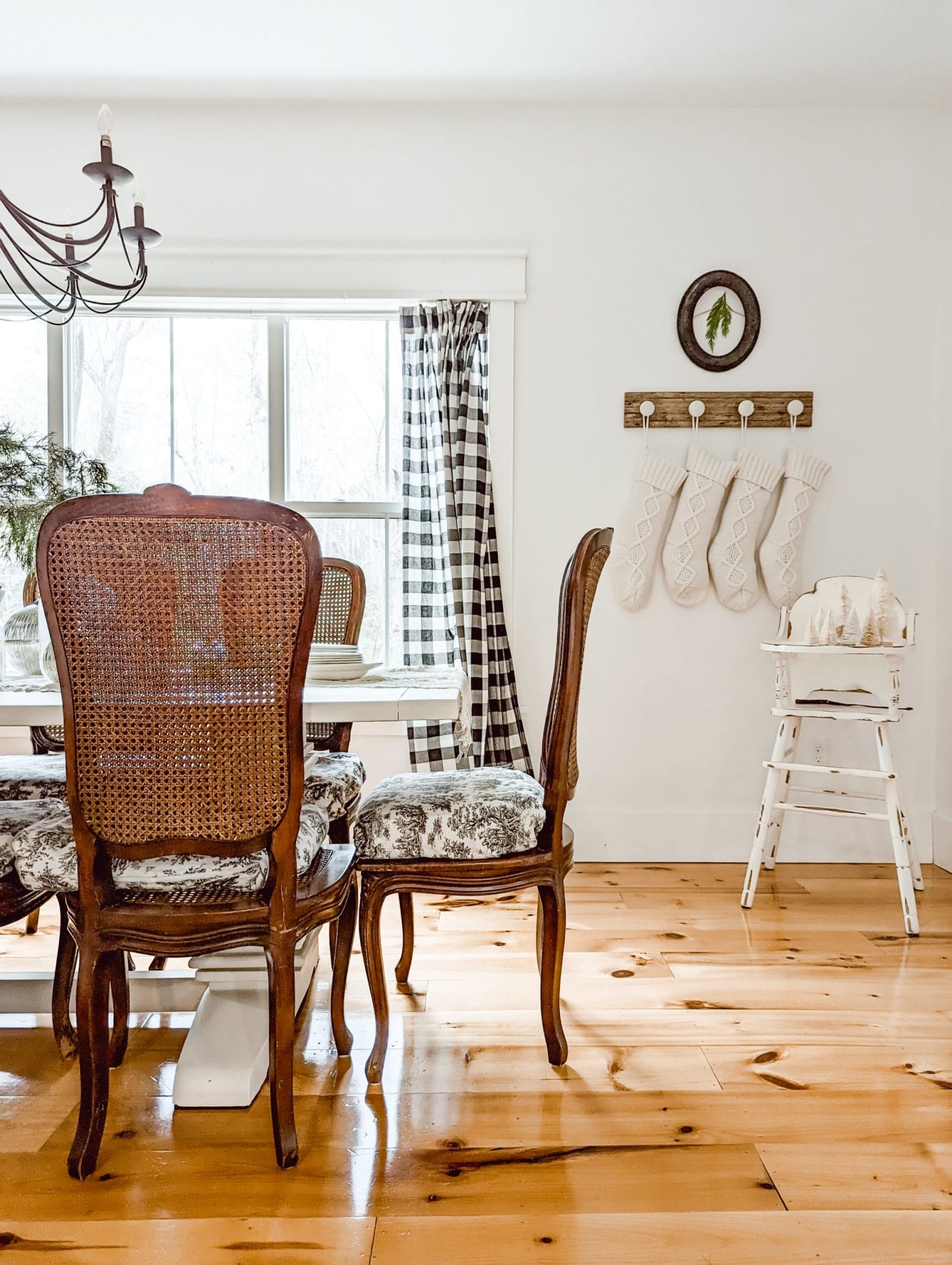 Fusion Mineral Paint on a white farmhouse style trestle table in a white and wood dining room with antique wood caned chairs decorated for Christmas