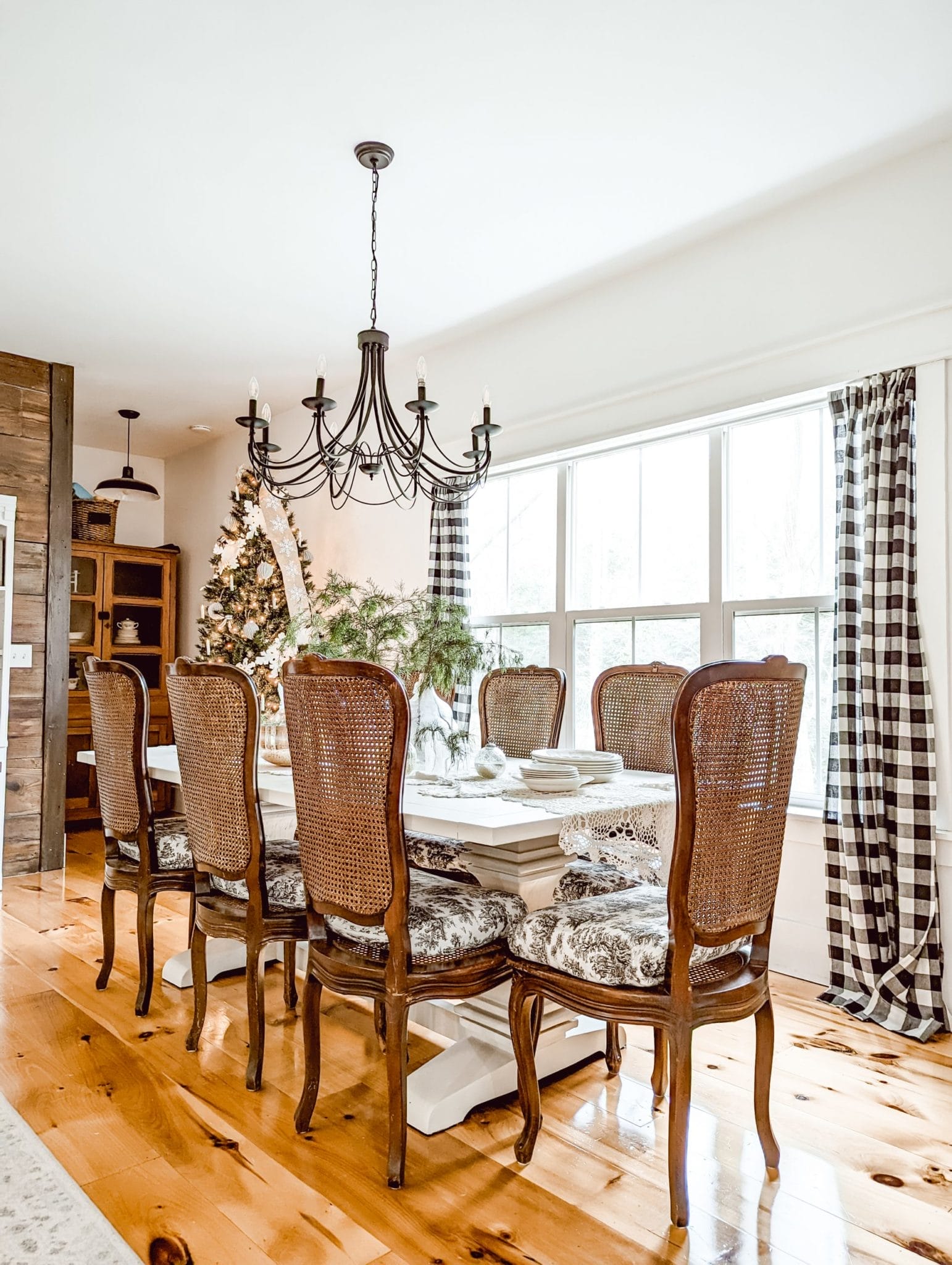 Fusion Mineral Paint Raw Silk on a farmhouse style trestle table in a white and wood dining room with antique wood caned chairs decorated for Christmas
