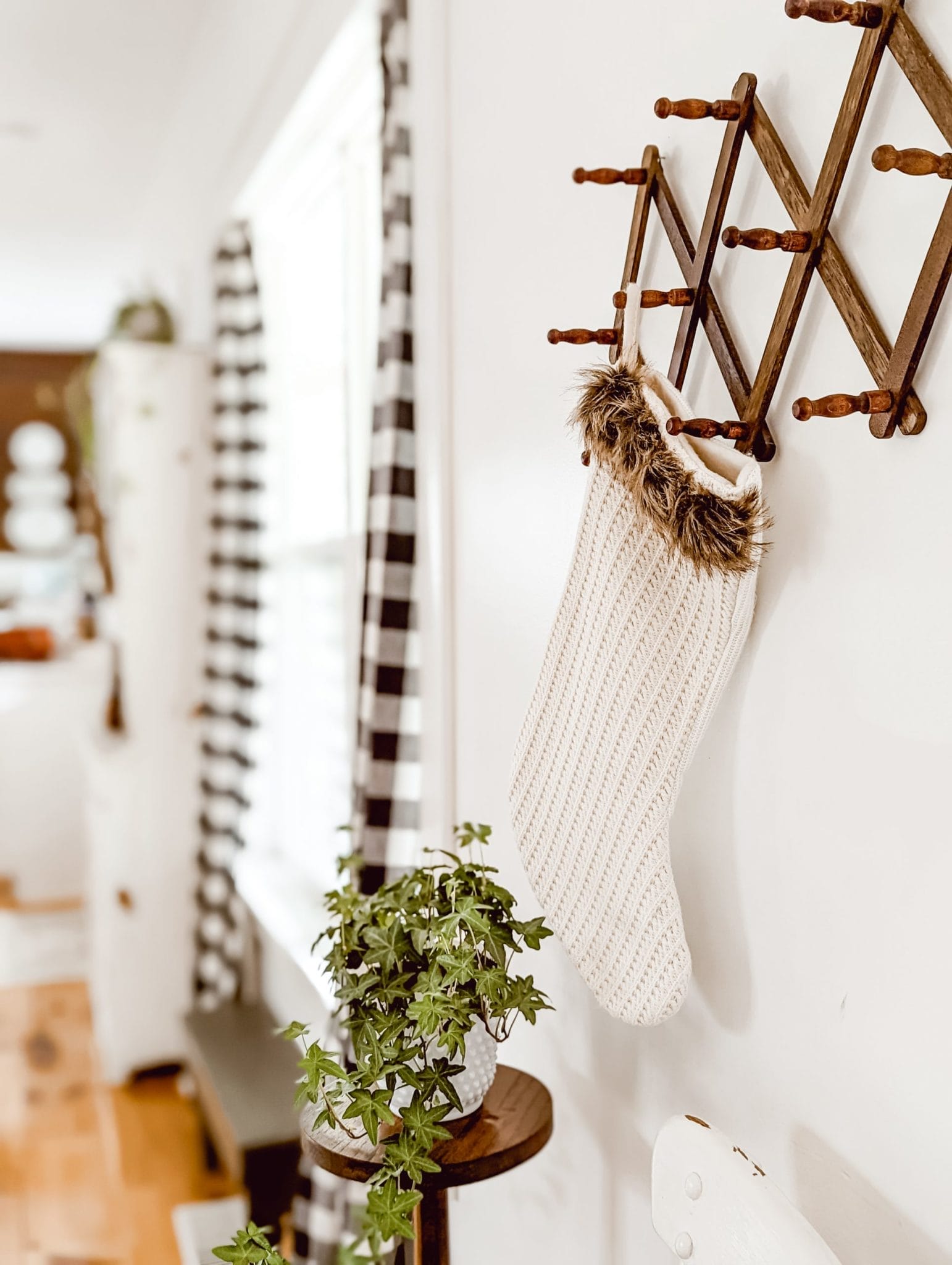 white knit Christmas stocking hanging from vintage wood accordion rack