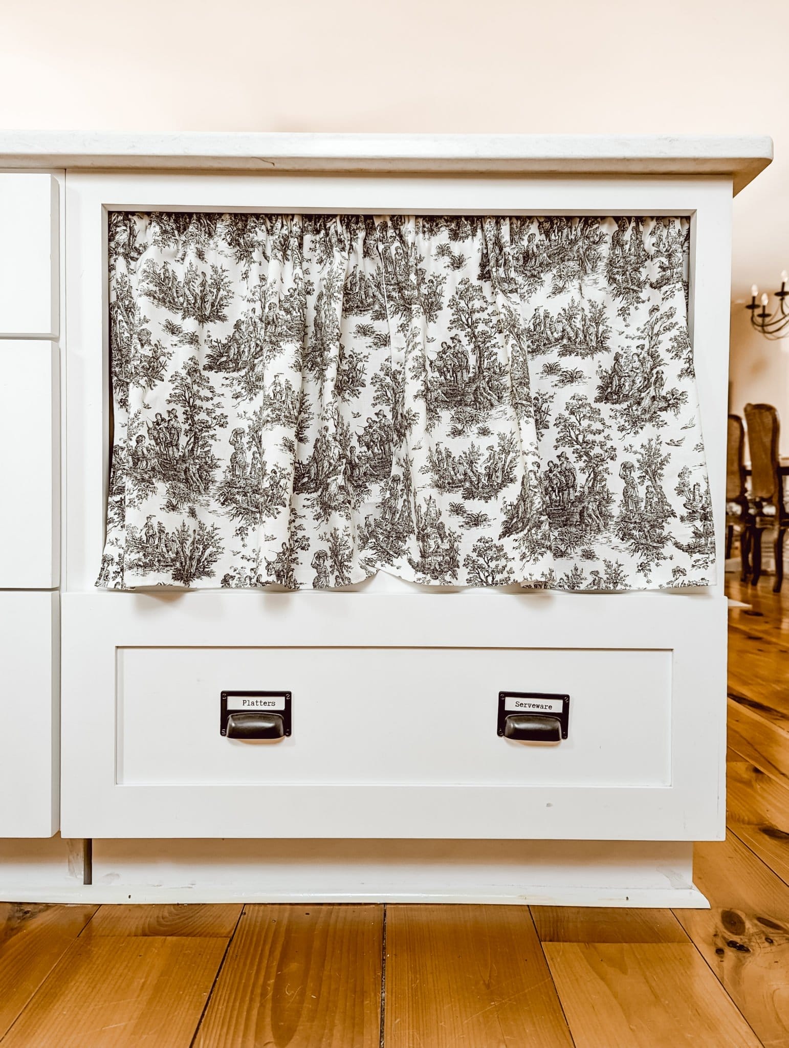 black and white toile curtains on a kitchen cabinet