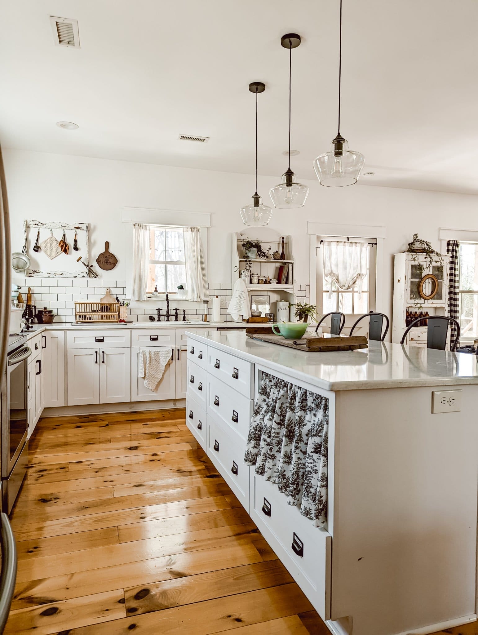 white farmhouse cottage kitchen with an island full of drawers and white quartz countertops