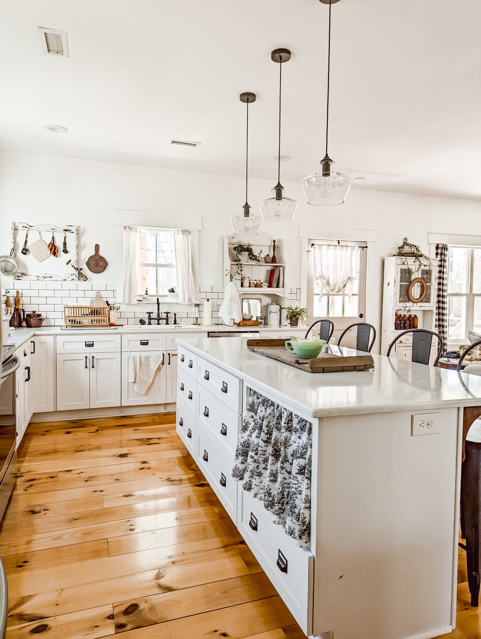 Behr Bit of Sugar in our all white farmhouse kitchen with white shaker cabinets and white quartz countertops and pine wood floors