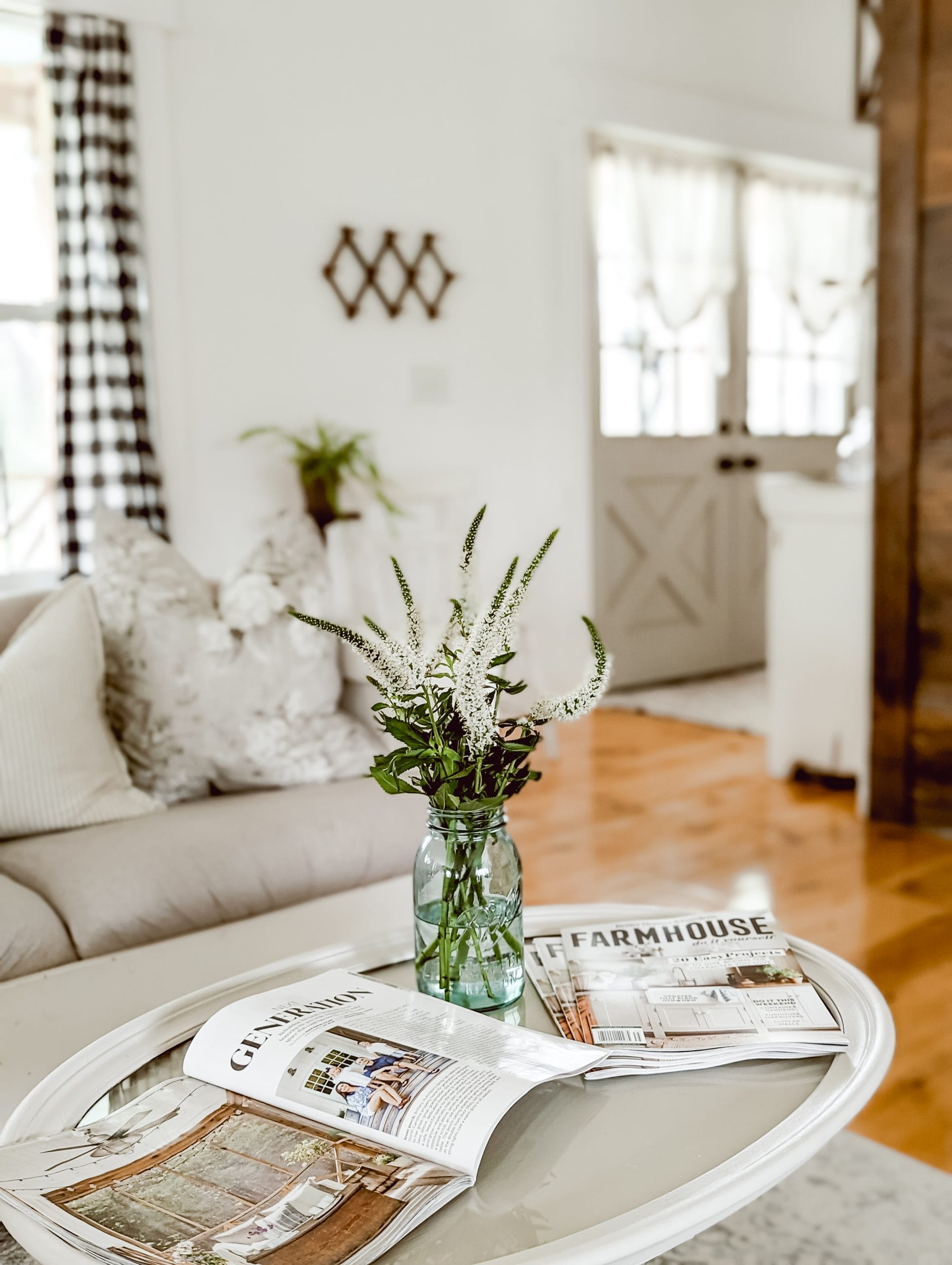 Veronica "white wand" flowers arranged in a blue ball mason jar in a cottage farmhouse style living room