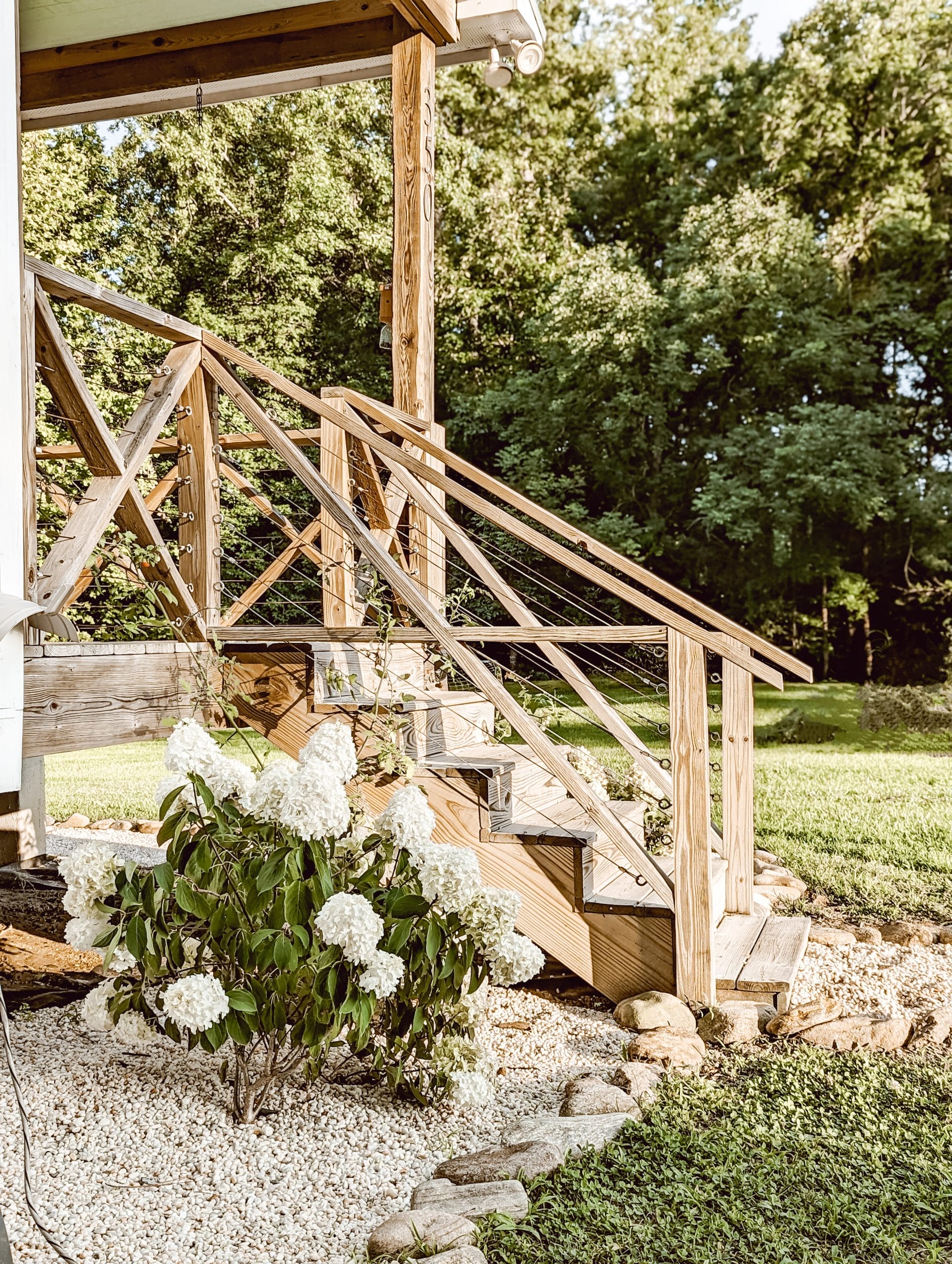white wedding panicle hydrangeas by the porch steps of our NC farmhouse landscaping surrounded by pea gravel