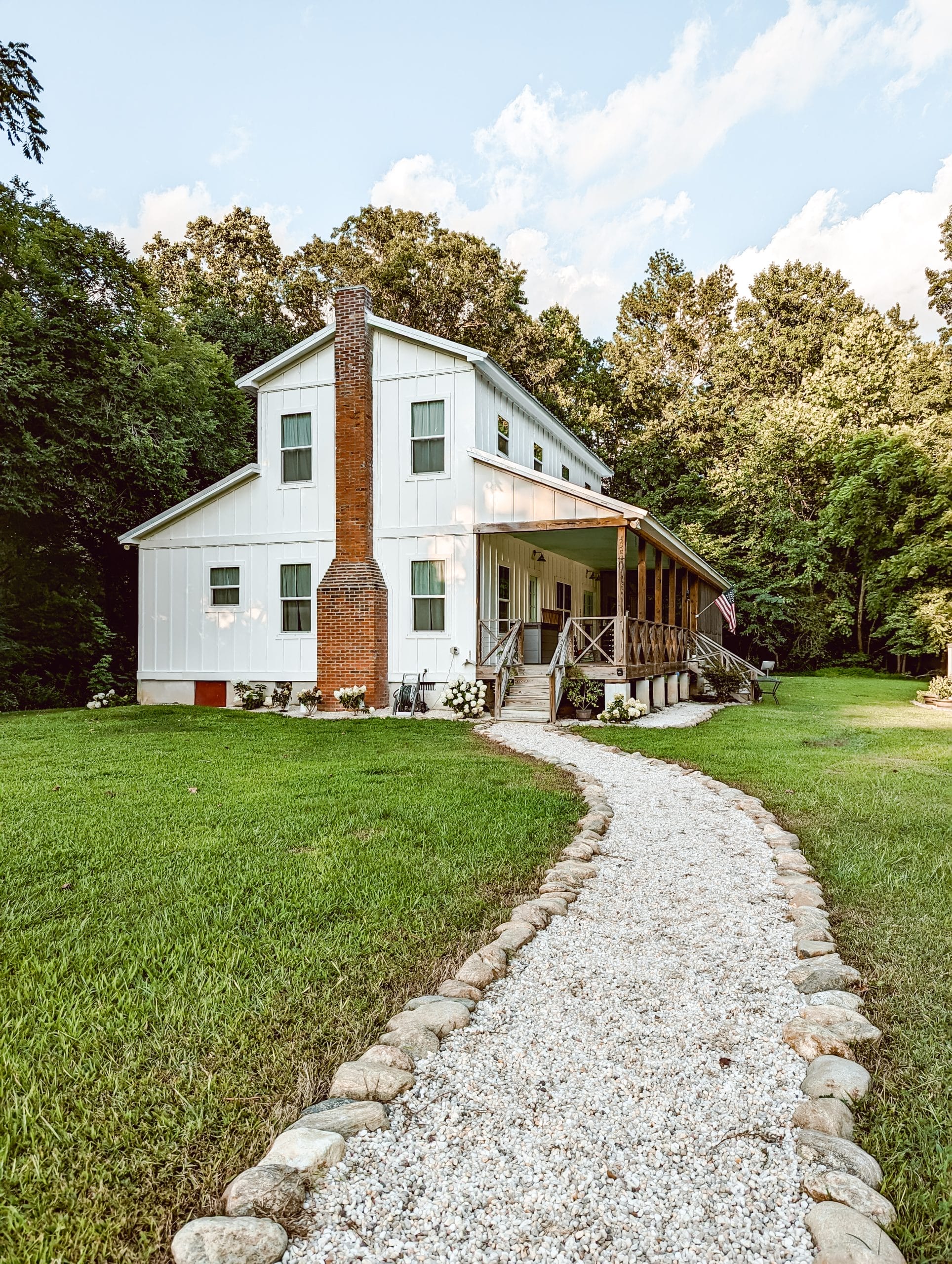 a cottage garden path lined with natural stone border and filled with white pea pebbles