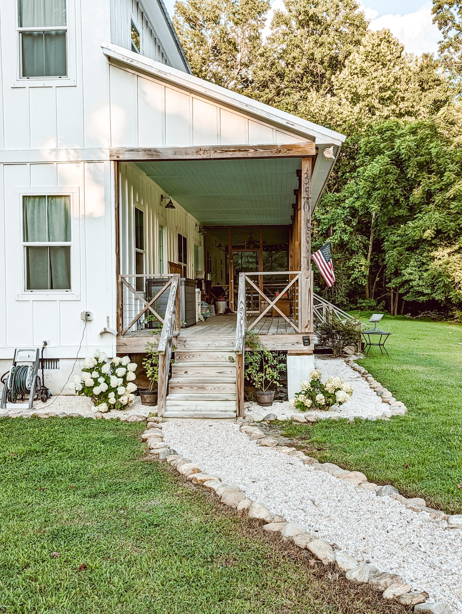 country farmhouse front porch steps leading to a gravel walkway