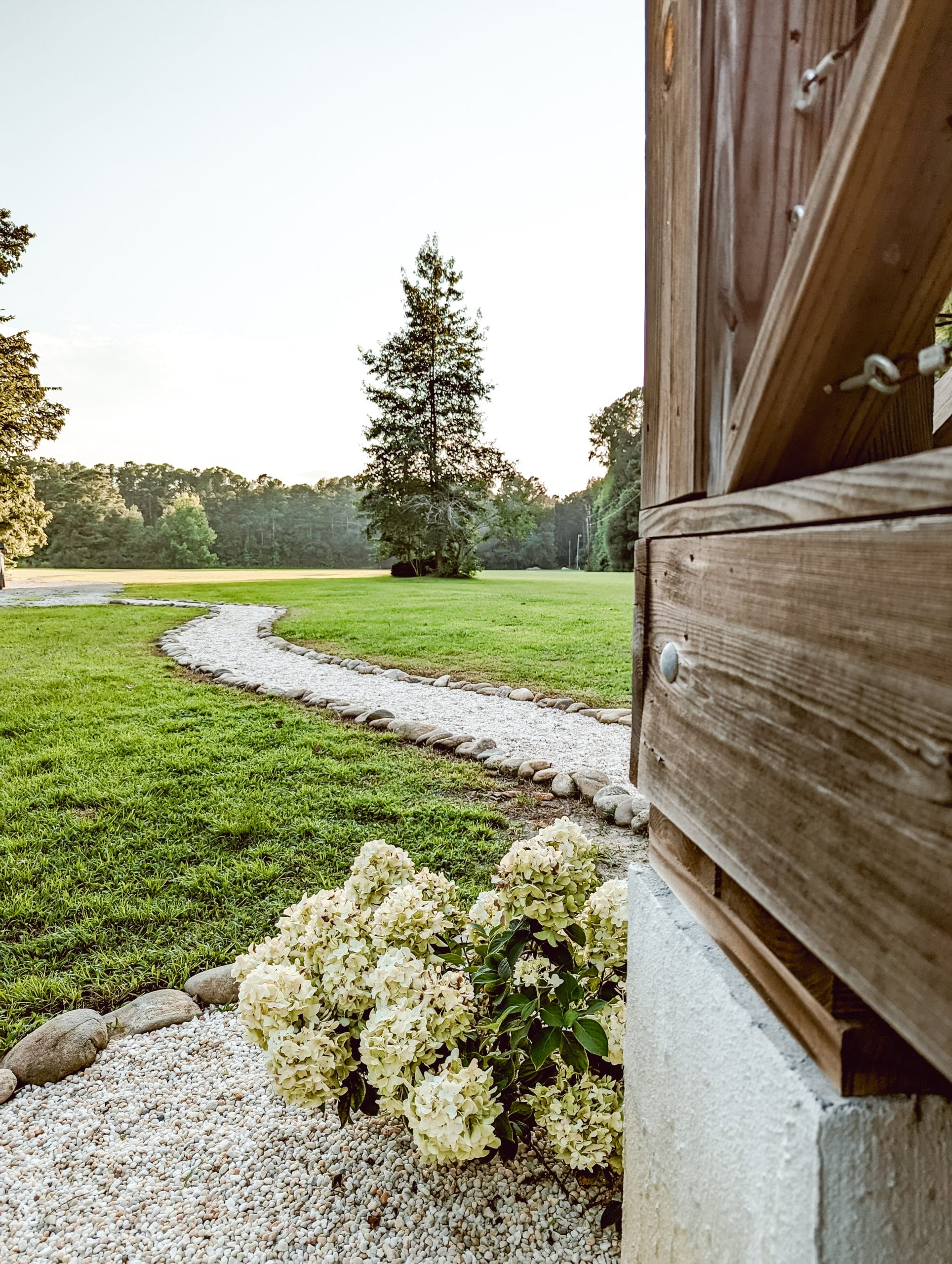 Simple Country Farmhouse Landscaping Ideas with Stone Flower Bed Edging -  White and Woodgrain, image size:1928x2560