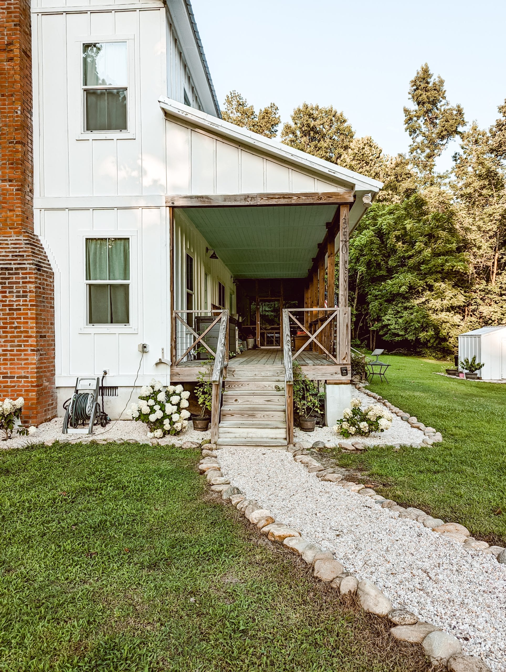 farmhouse hardscaping with pea gravel walkway, lined with natural stone edging