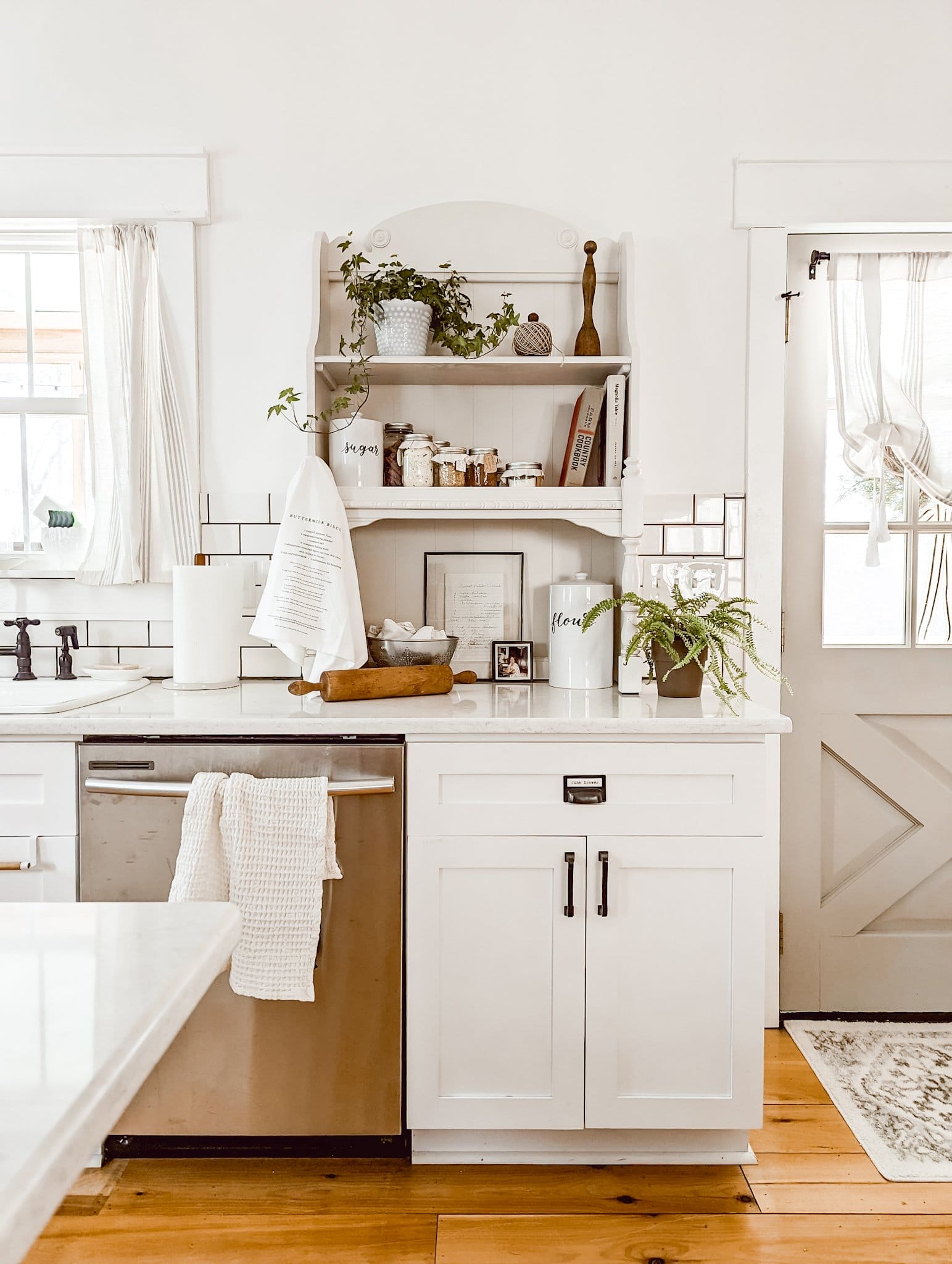 clean white kitchen with vintage kitchen decor, shaker cabinets, white subway tile backsplash, and open shelving