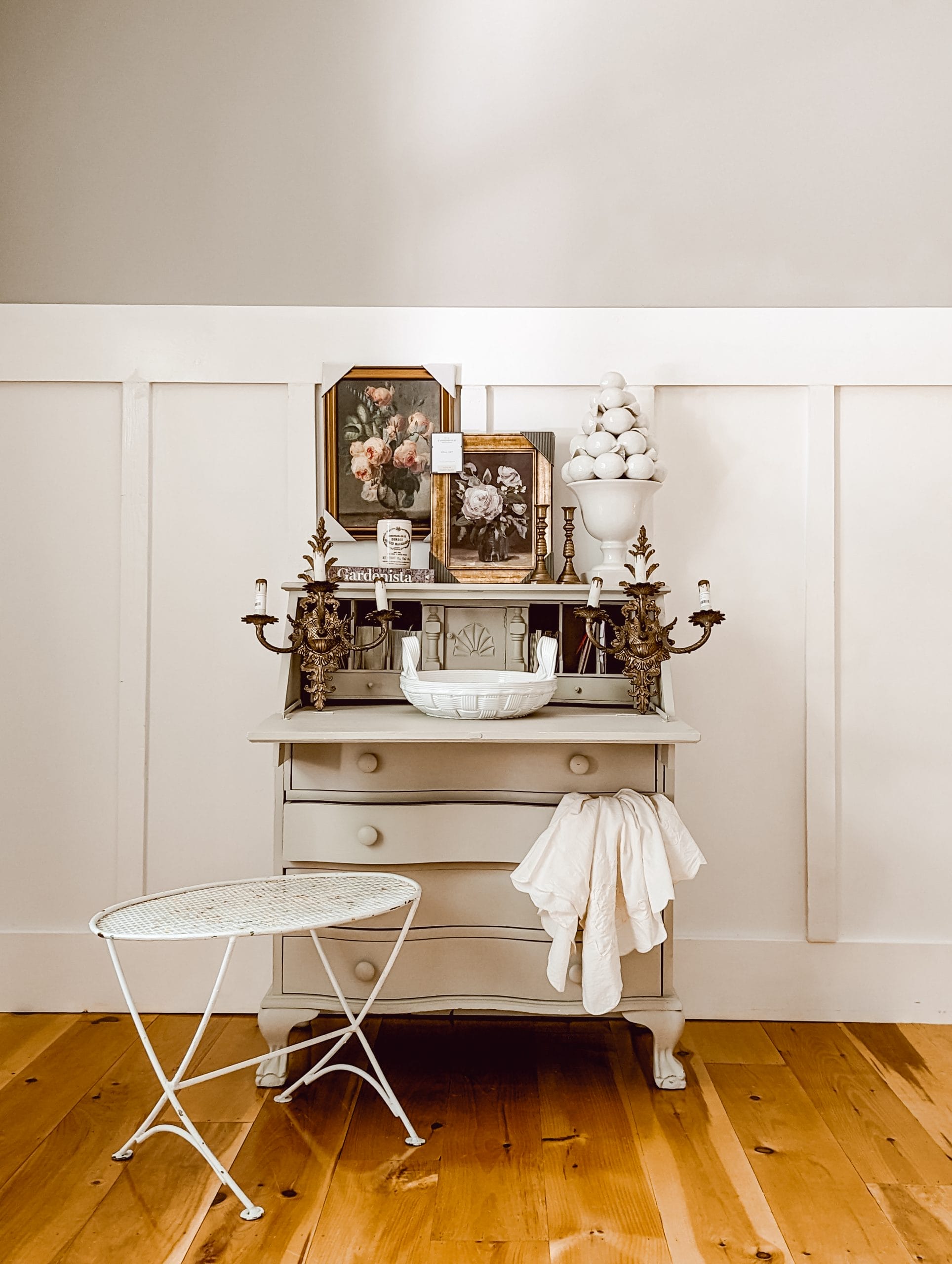 thrift store home decor haul including white metal outdoor table, brass sconce lights, framed art and white porcelain lemon topiary pottery