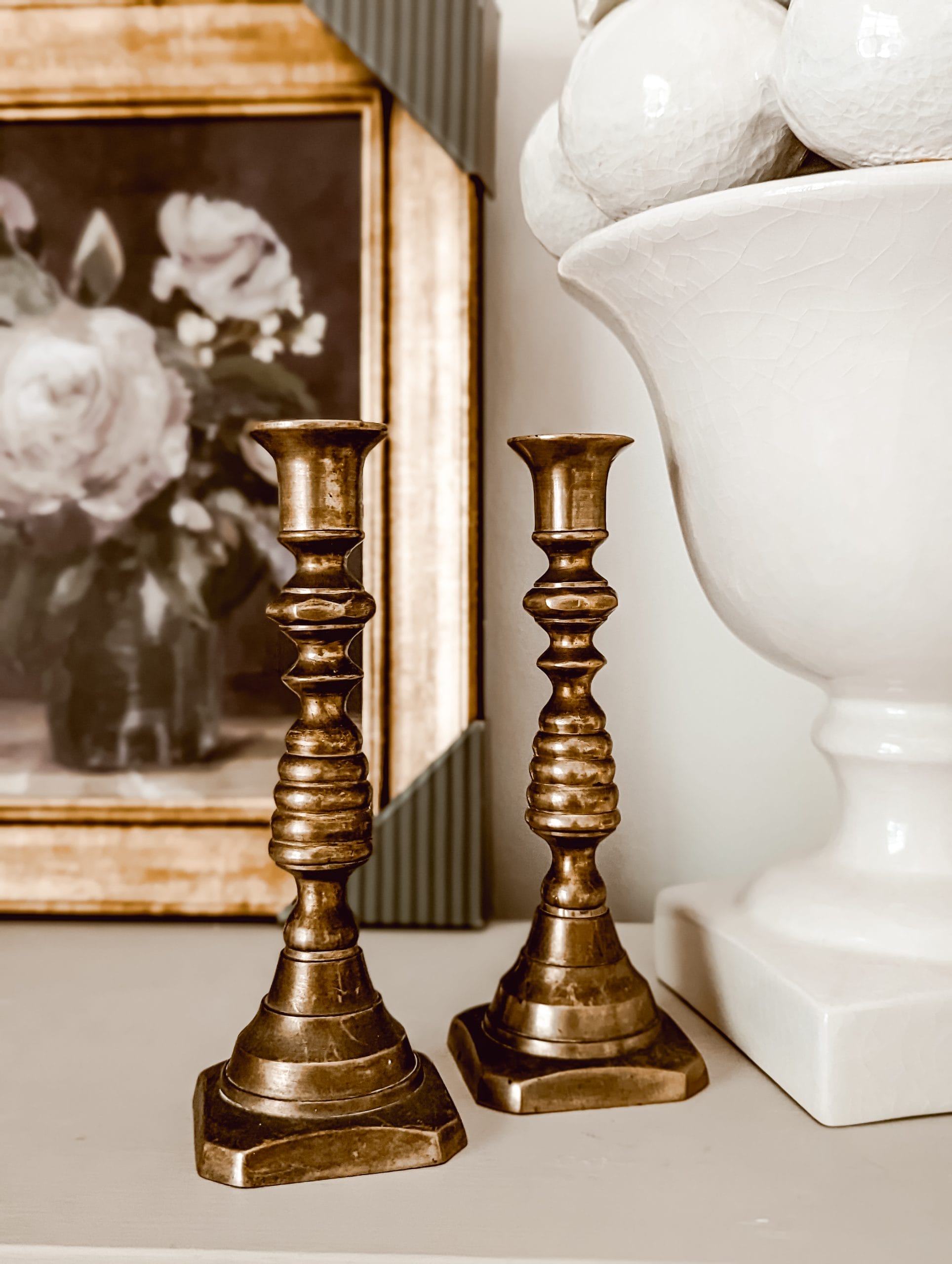 two vintage brass candlesticks with wax pushers