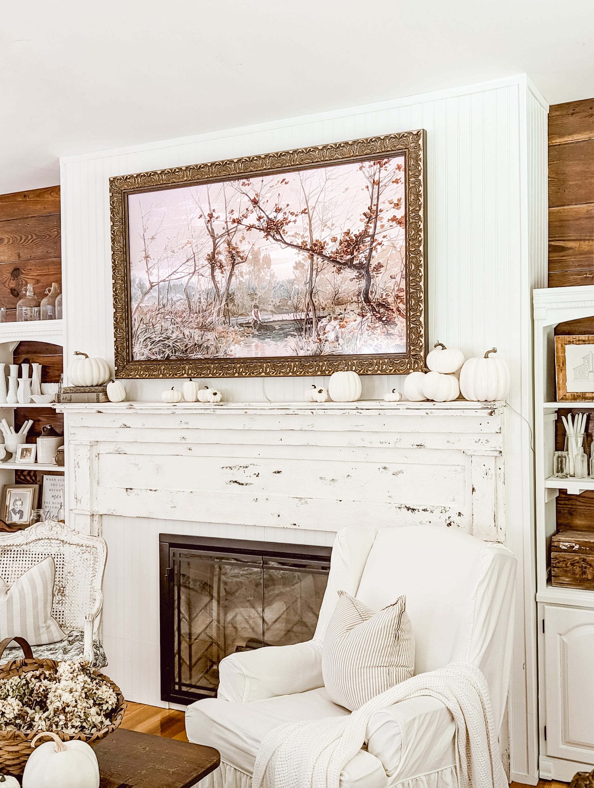 Samsung frame TV with a gold Deco TV Frame above an antique mantel and electric fireplace decorated with white pumpkins for fall