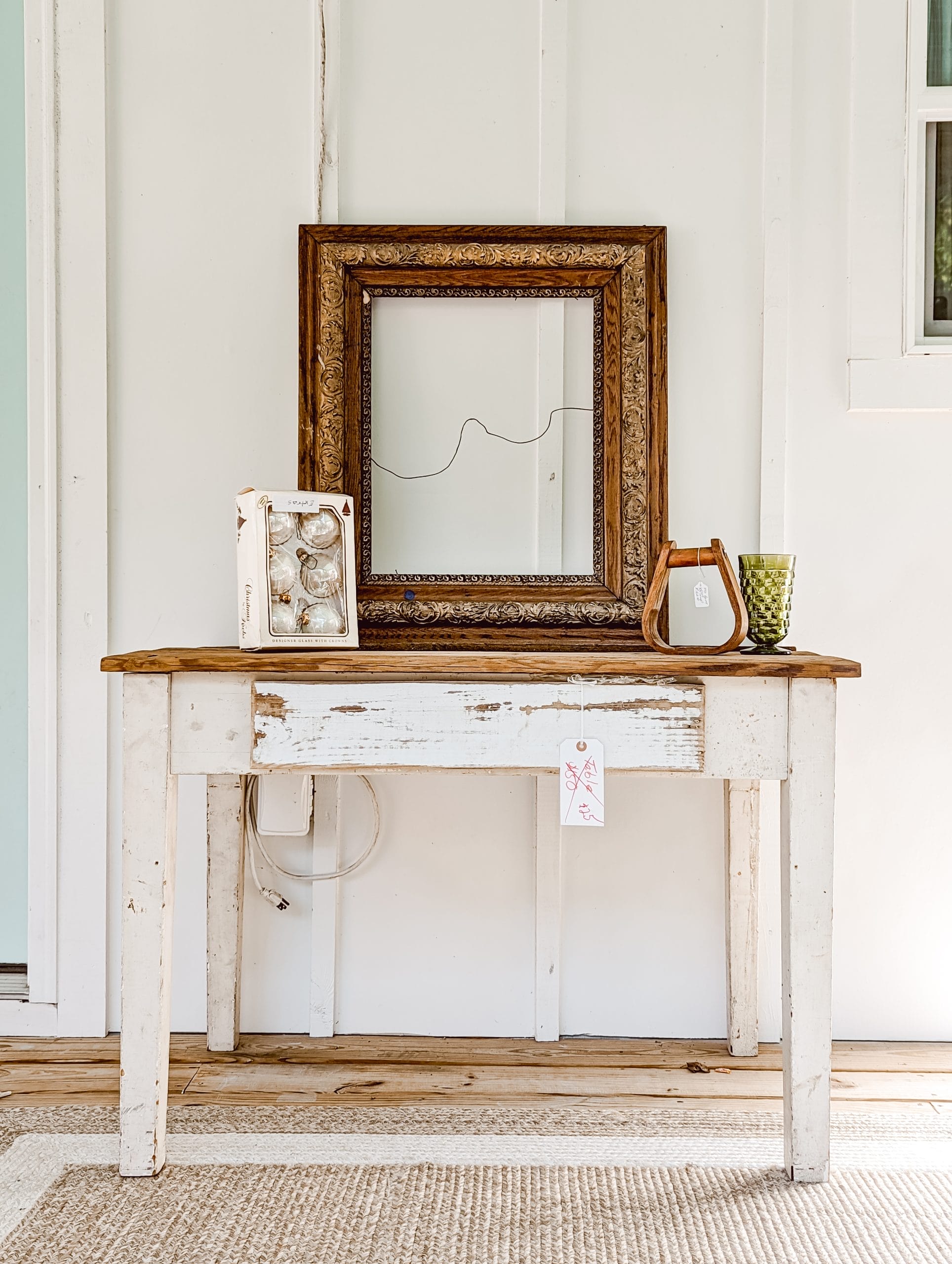 vintage haul from the Liberty Antique Festival in Staley North Carolina including a white and wood table, an antique wood frame, vintage Christmas ornaments, a wooden stirrup, and vintage whitehall glassware