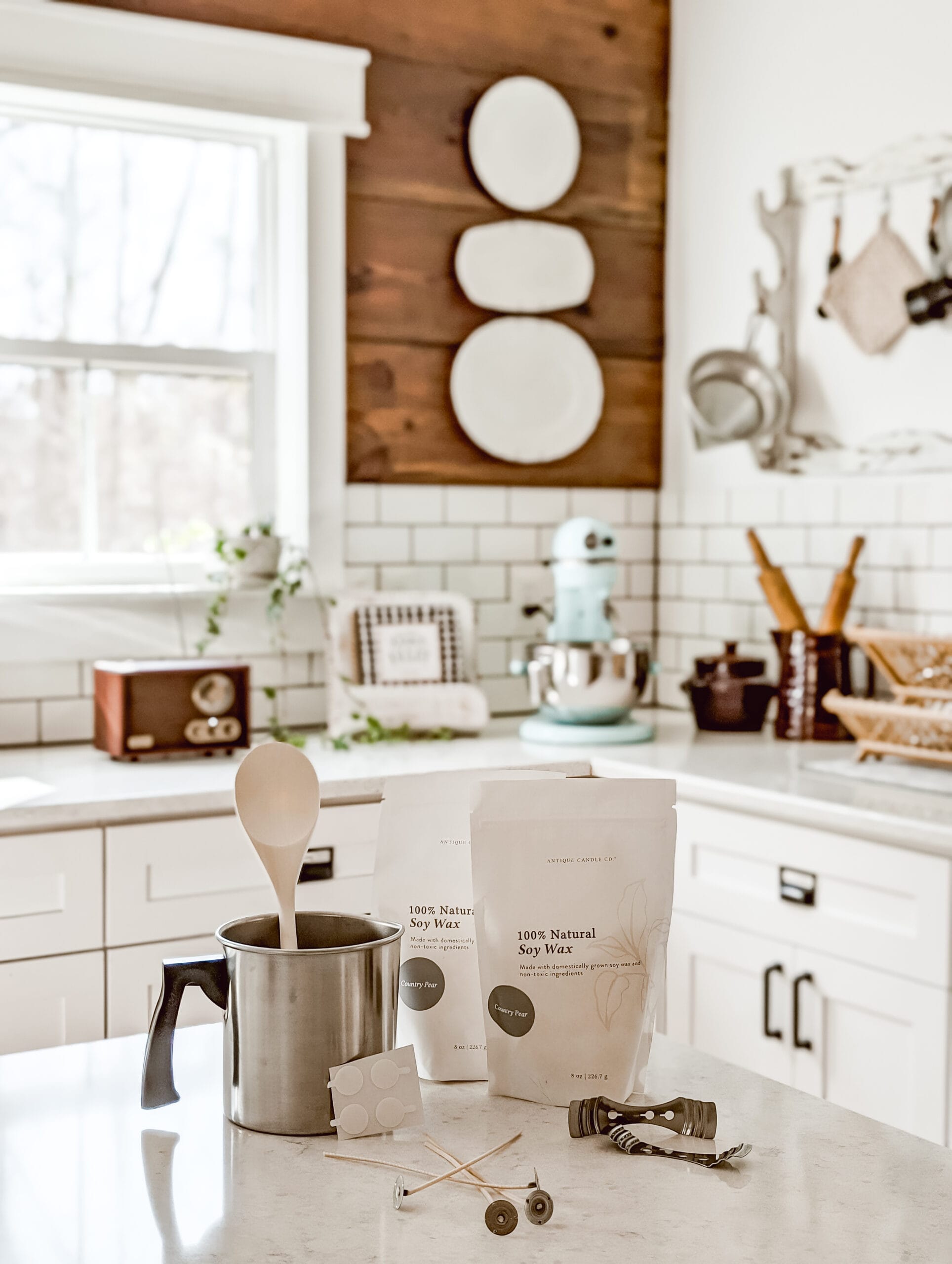 DIY candle making kit from Antique Candle Co. that includes scented wax melts, a wax melting pot, a wooden spoon, cotton wicks, wick stickers, and metal wick holders