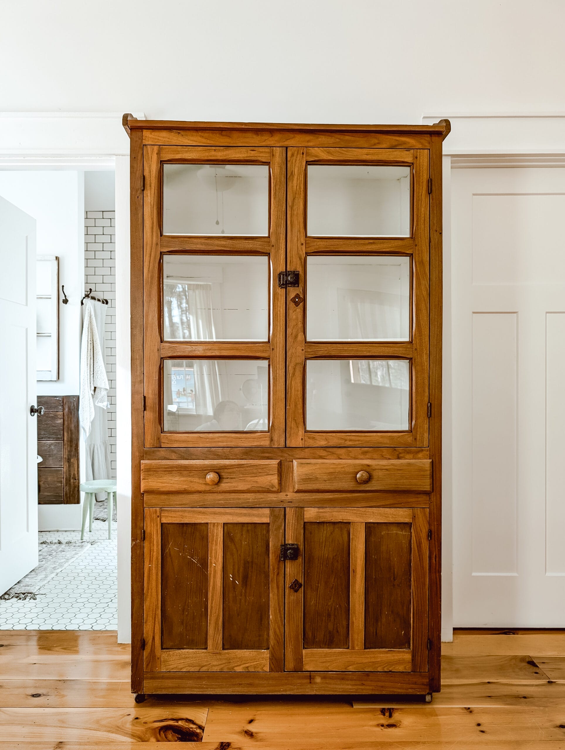 tall antique wood cabinet with glass upper cabinet doors, 2 drawers, and wood lower cabinet doors,