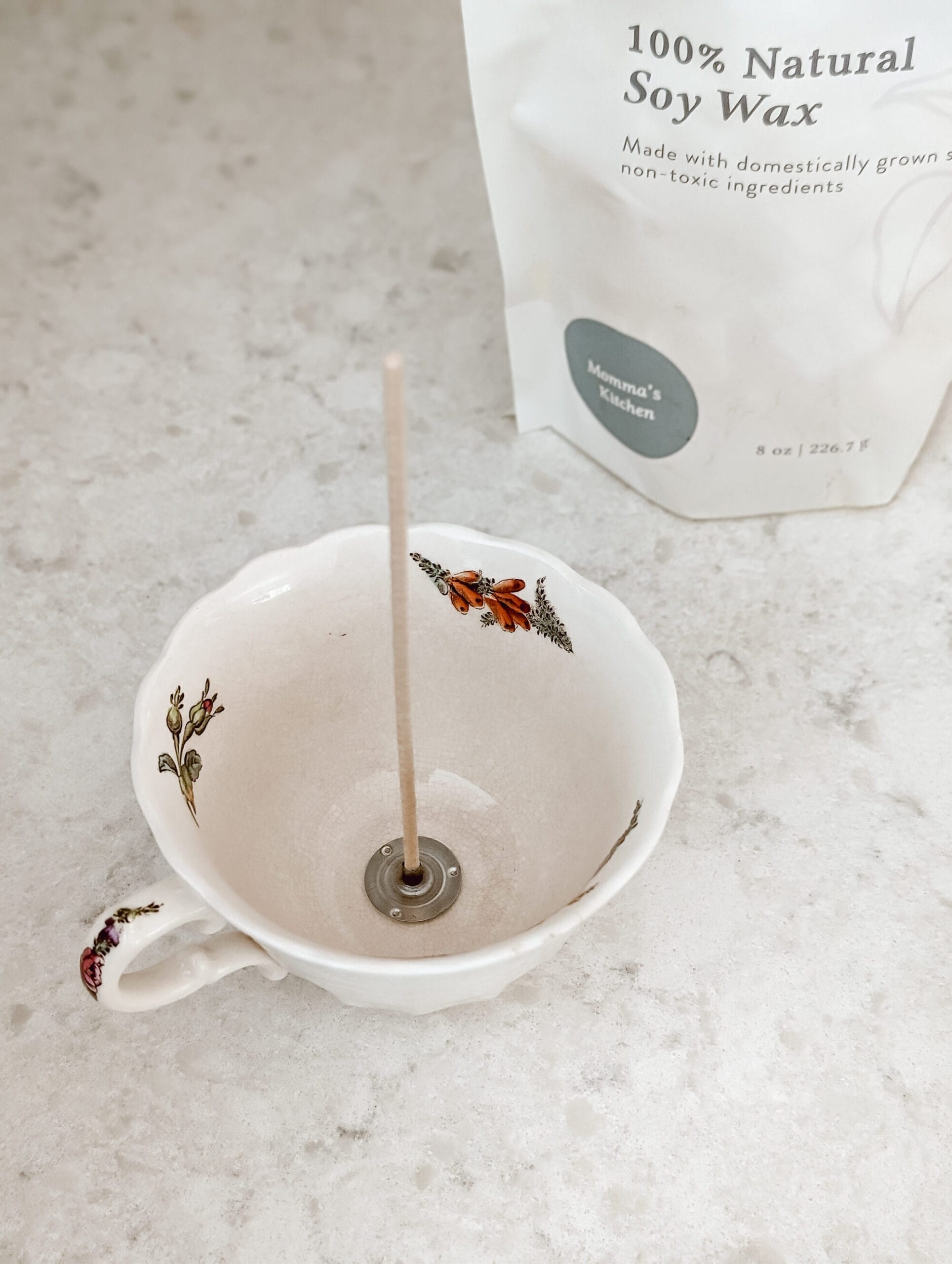 attaching a cotton candle wick to a vintage floral teacup to make a DIY candle