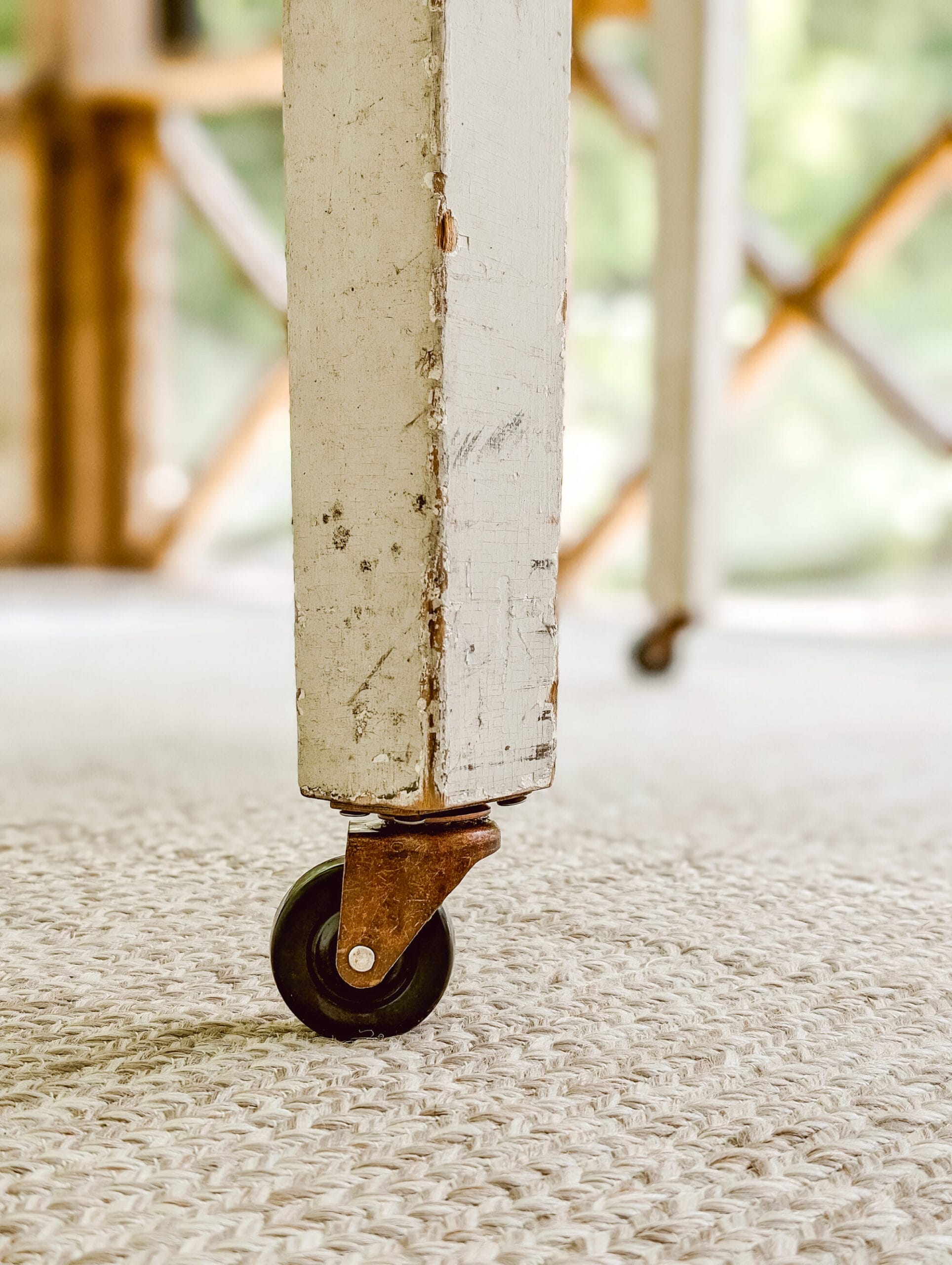 brass and rubber caster wheel on a wooden table leg