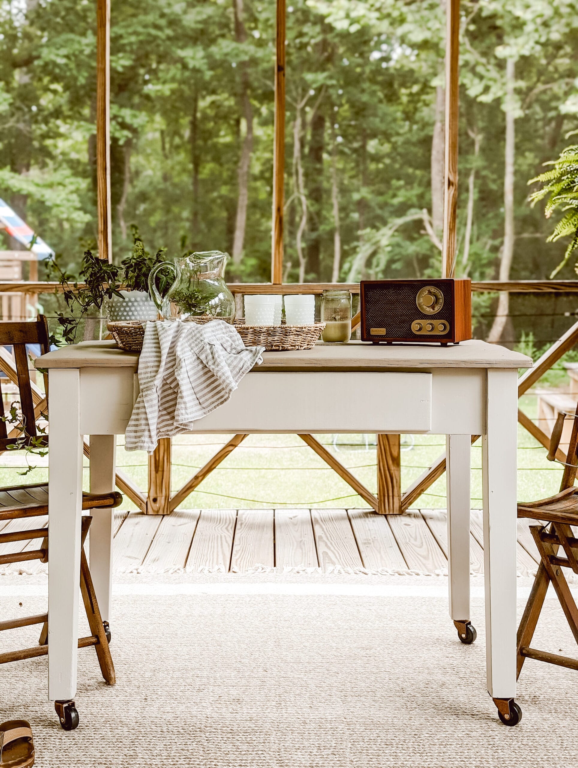 freshly painted white and brown rolling porch table on caster wheels