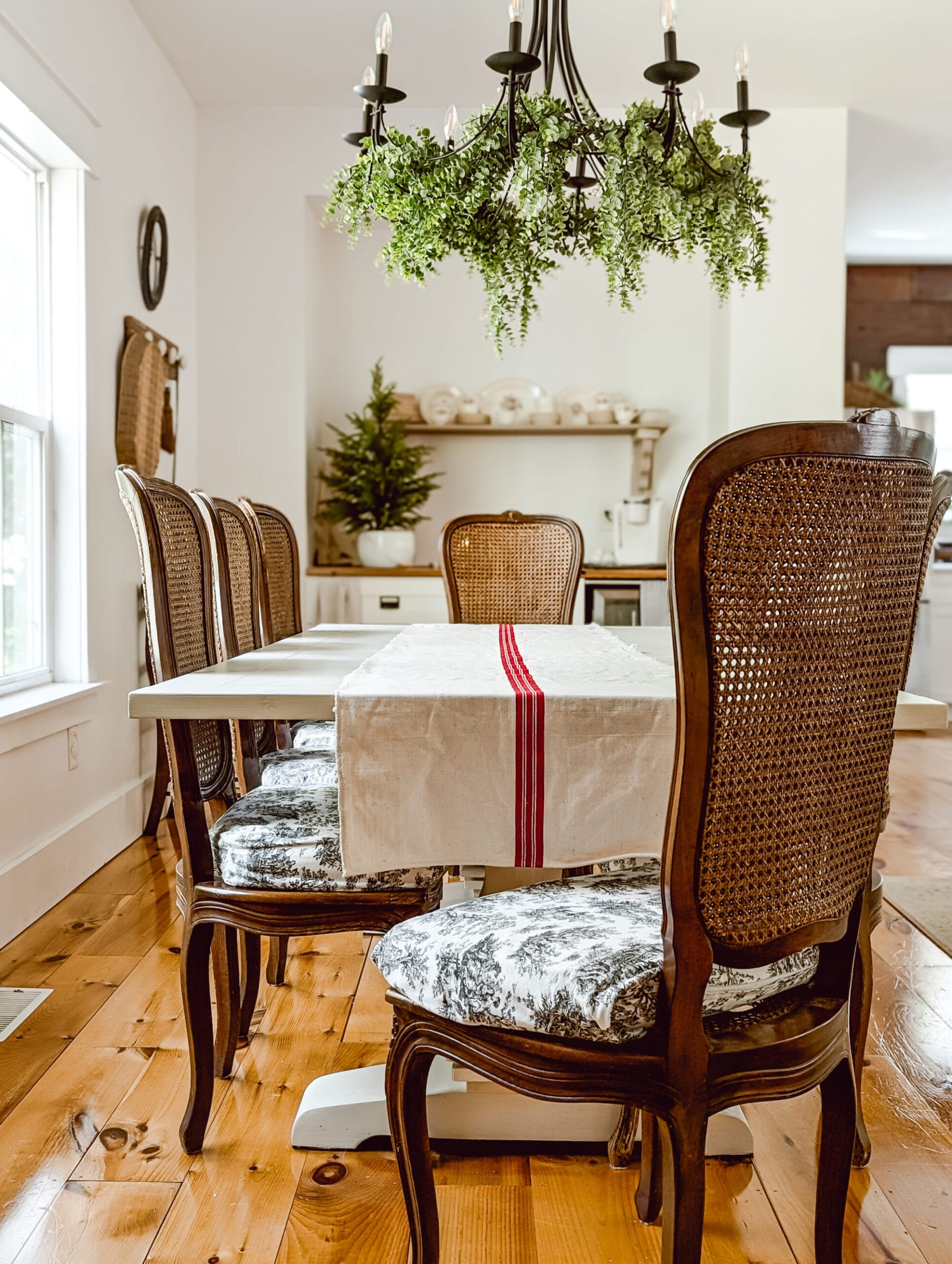 antique grain sack table runner on a white painted farmhouse trestle table with vintage caned wood chairs