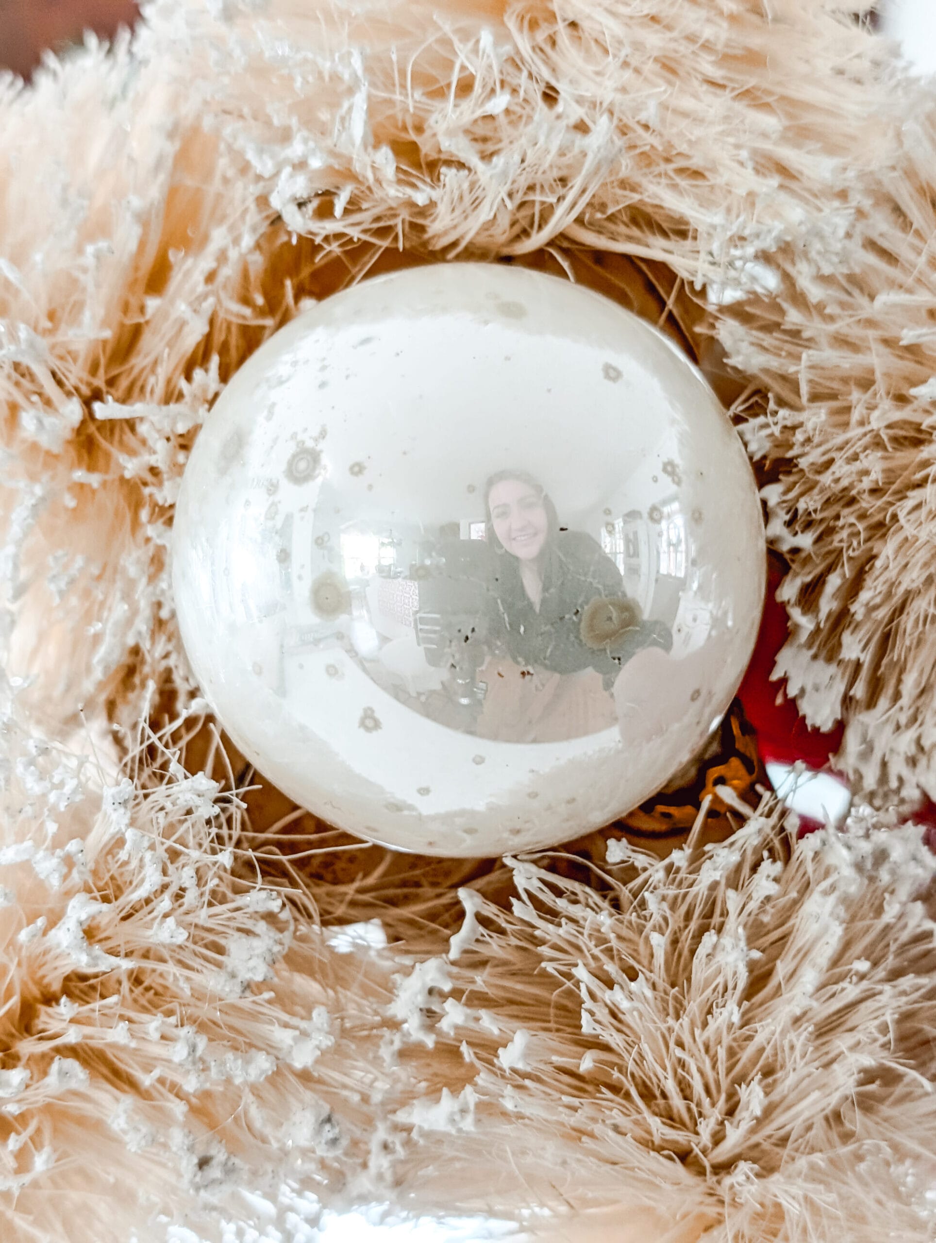 reflection showing in an antique white ball Christmas ornament