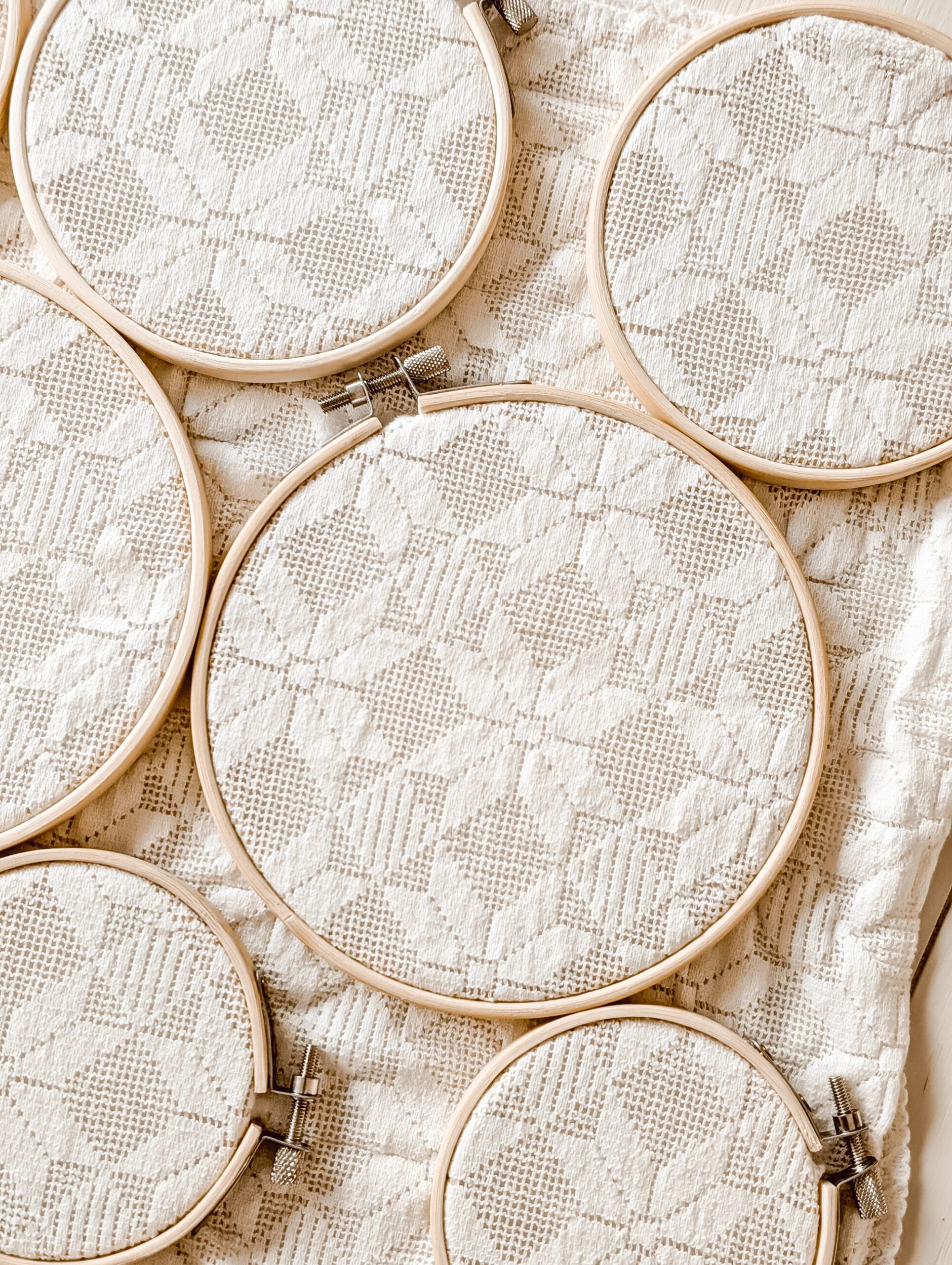 wooden embroidery hoops attached to a piece of vintage lace fabric